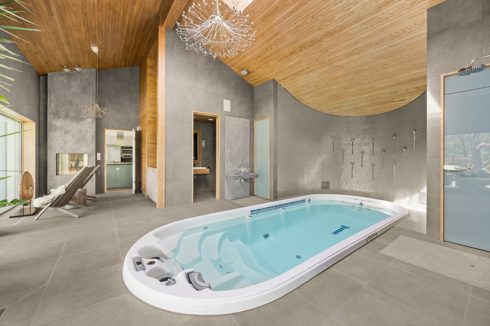 Stort motstrømsbasseng med massasjedyser - som er pent plassert i midten av rommet Galleribilde