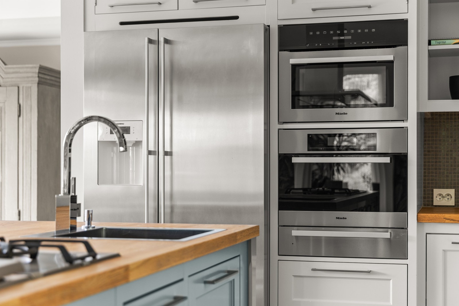 Frittstående side-by-side kjøle-/fryseskap med dispenser, integrert dampovn i høyskap (Miele) og integrert mikro-/stekeovn i høyskap (Miele) Galleribilde