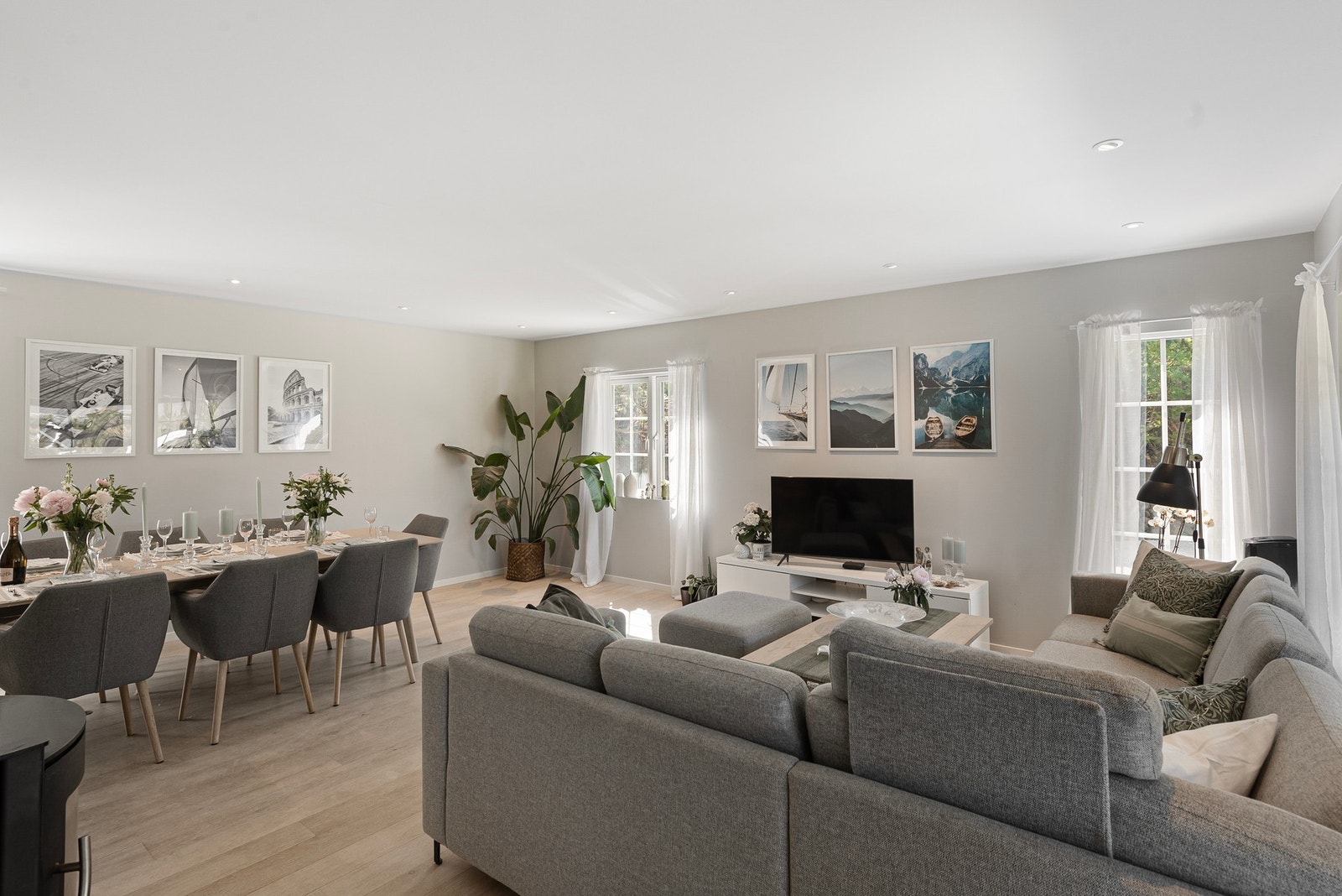 En lys og romslig enebolig med glatte flater, store vindusflater og downlights i oppholdsrom Galleribilde