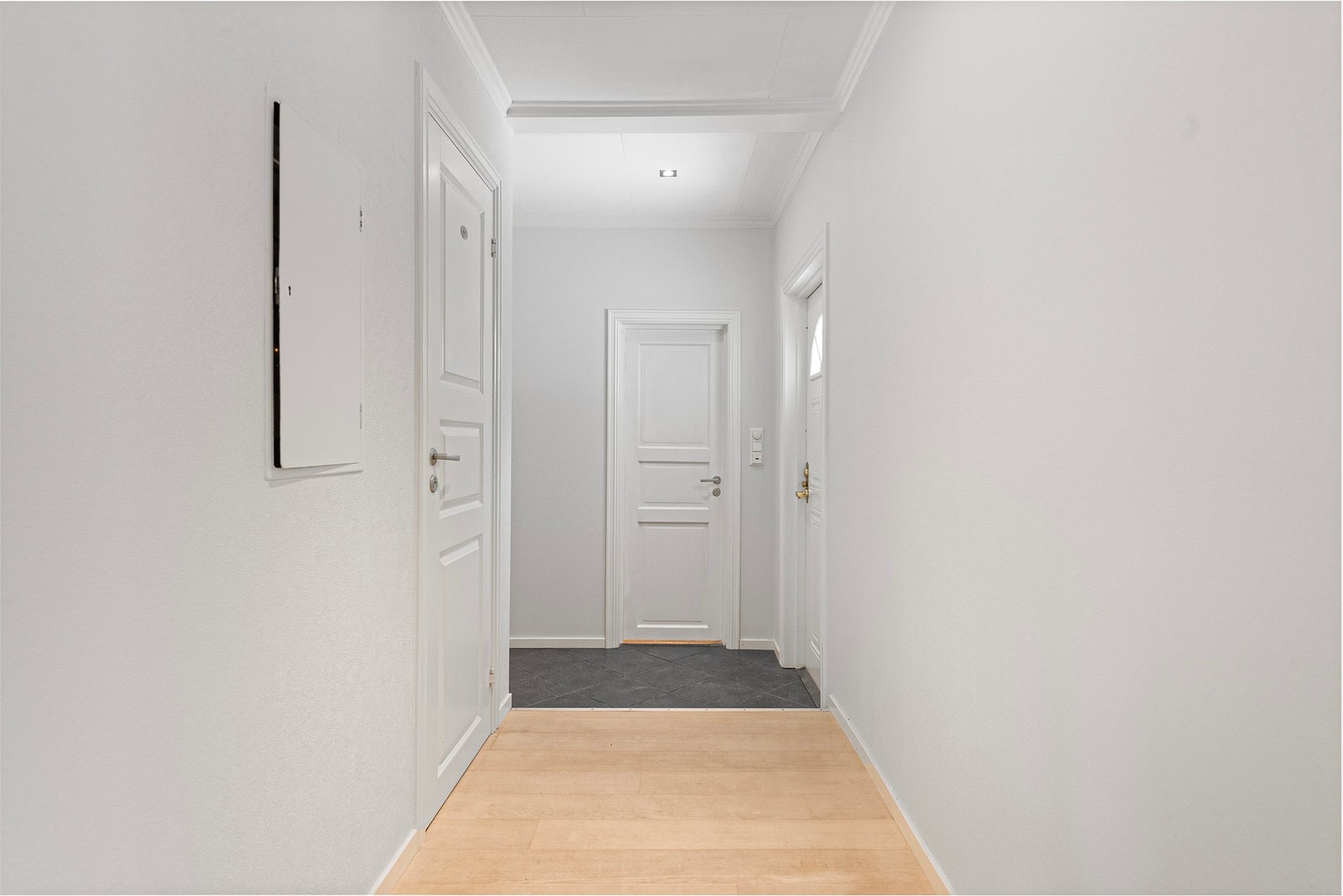 Fra entreen går du gjennom lys hall - forbi gjestetoalett og bad - før du kommer inn i stue og kjøkken i åpen løsning Galleribilde