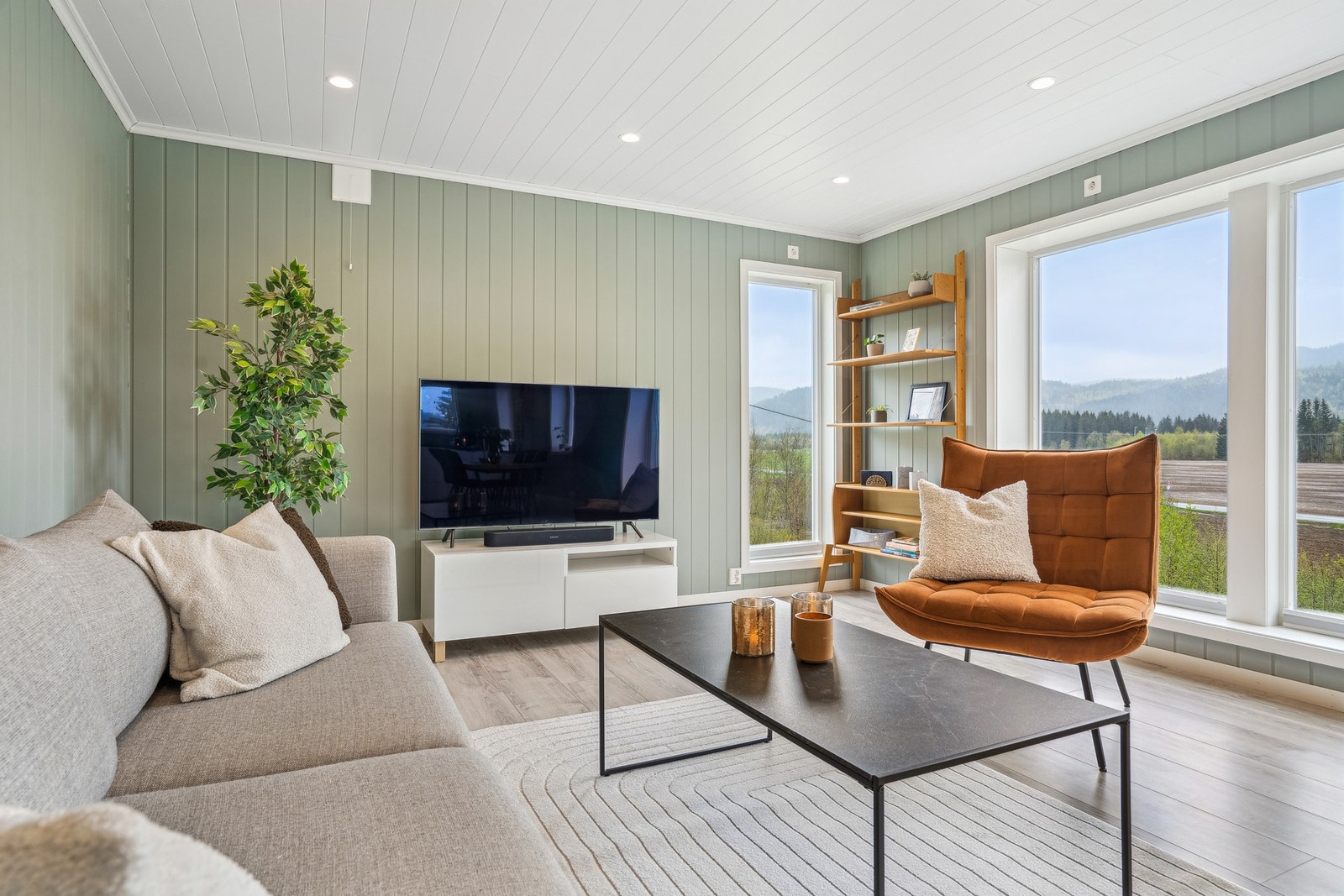 Store vindusflater fyller rommet med naturlig lys og skaper en behagelig romfølelse. Galleribilde