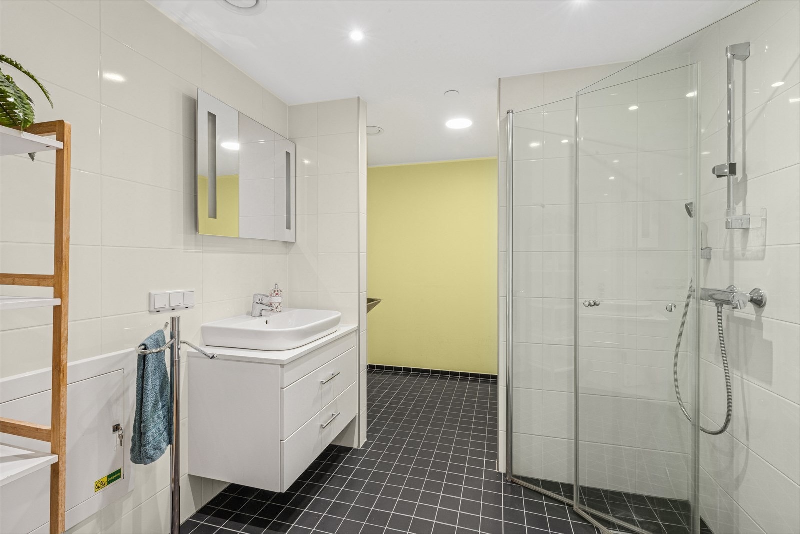 Flott innredet bad med hvit slett innredning med uttrekkbare skuffeseksjoner. Servant med ett-greps bladebatteri. Speil med belysning. Dusj med dusjvegger i glass. Galleribilde