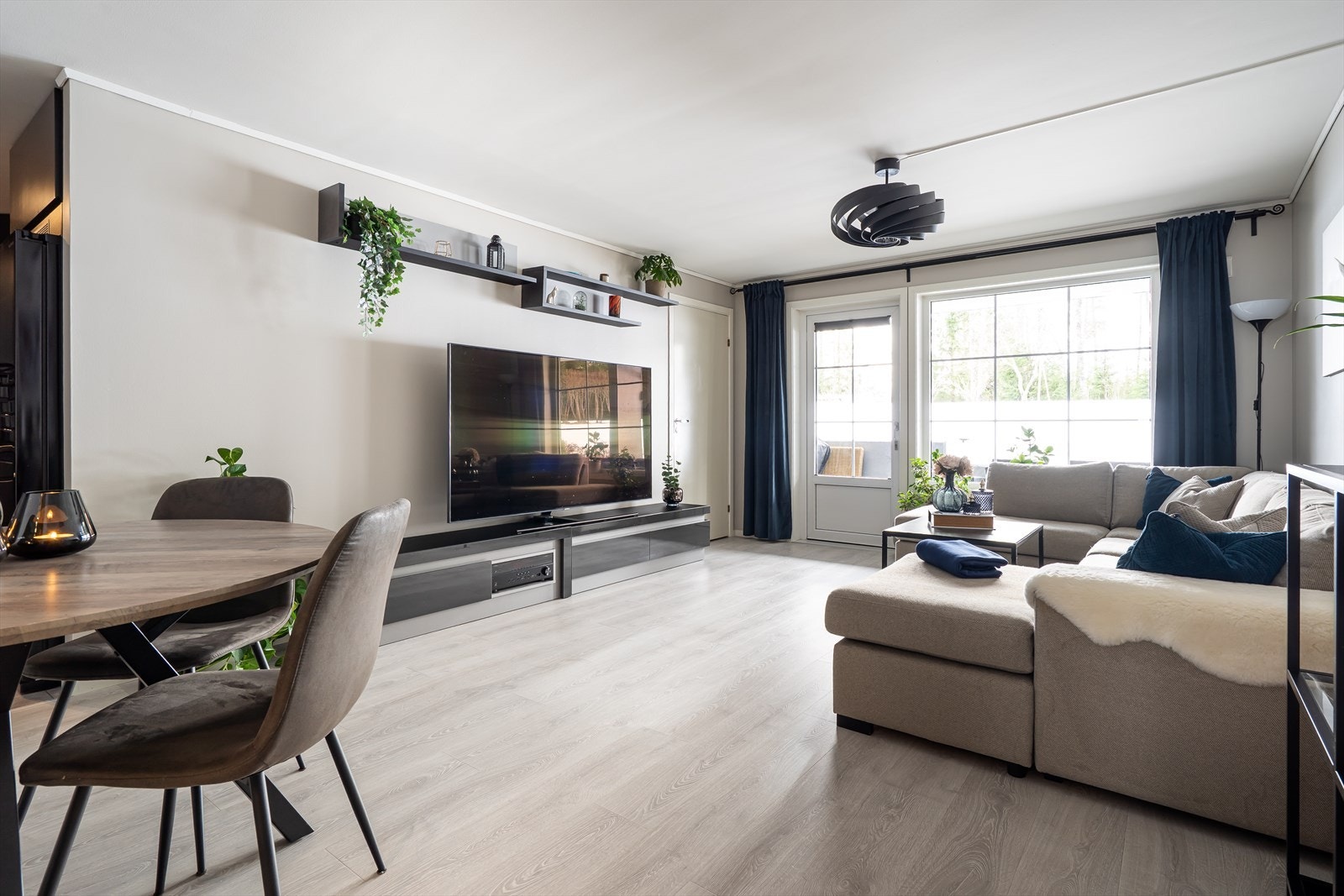 Et stort vindu bringer inn noe av det grønne, og stuen har utgang til verandaen - en herlig romforlengelse i sommerhalvåret. Galleribilde