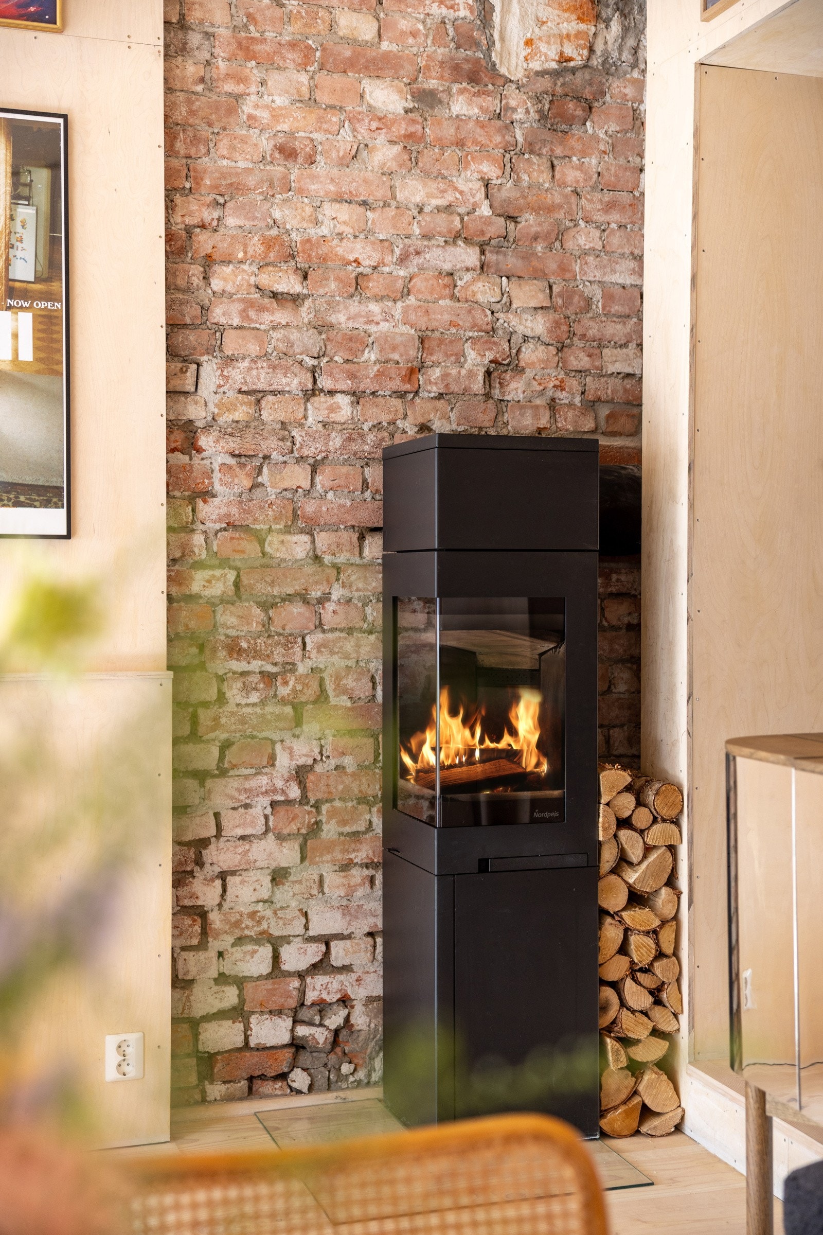 Vedovn med pipe i tegl varmer godt i kaldere årstider, i tillegg til å gi leiligheten en lun atmosfære. Galleribilde