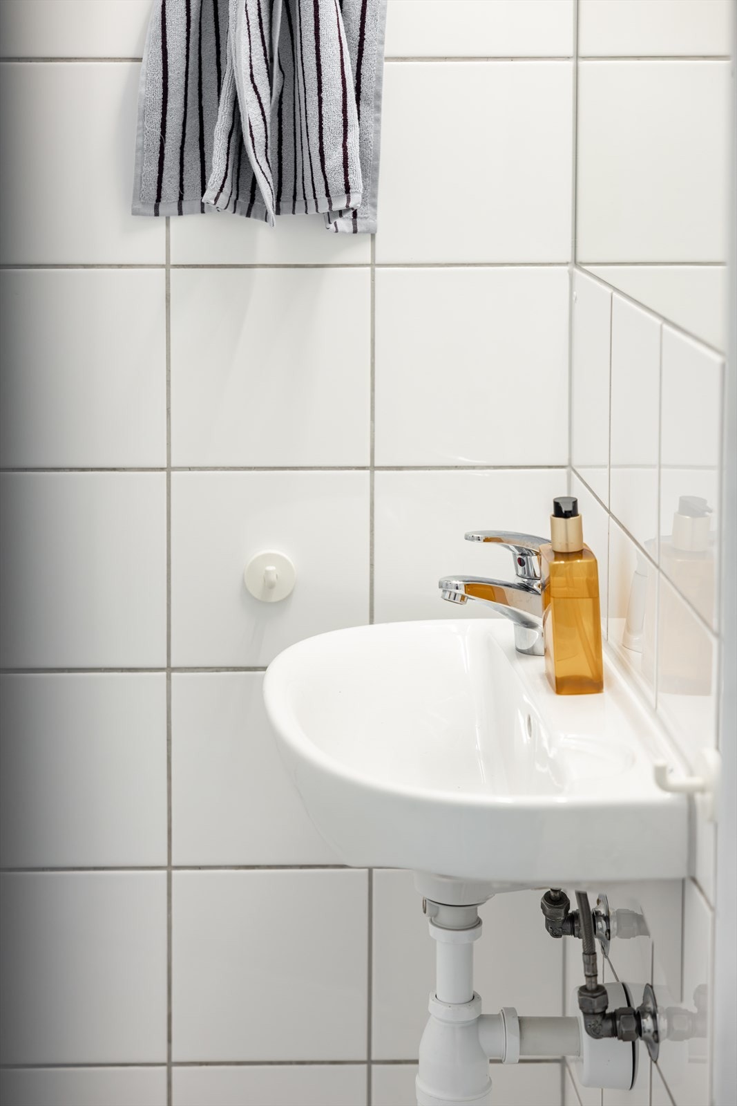 Badet er utstyrt med toalett, servant, speil og dusjhjørne. Galleribilde