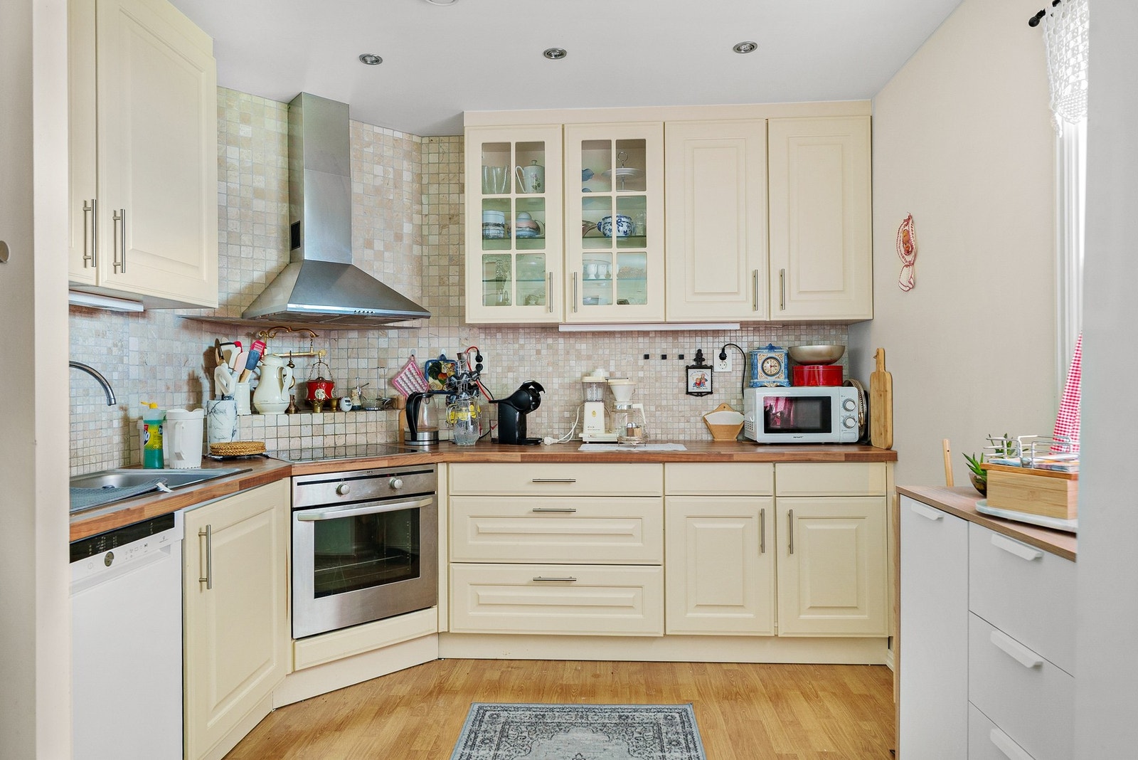 Kjøkken med integrerte hvitevarer, mekanisk avtrekk og vindu for naturlig belysning Galleribilde