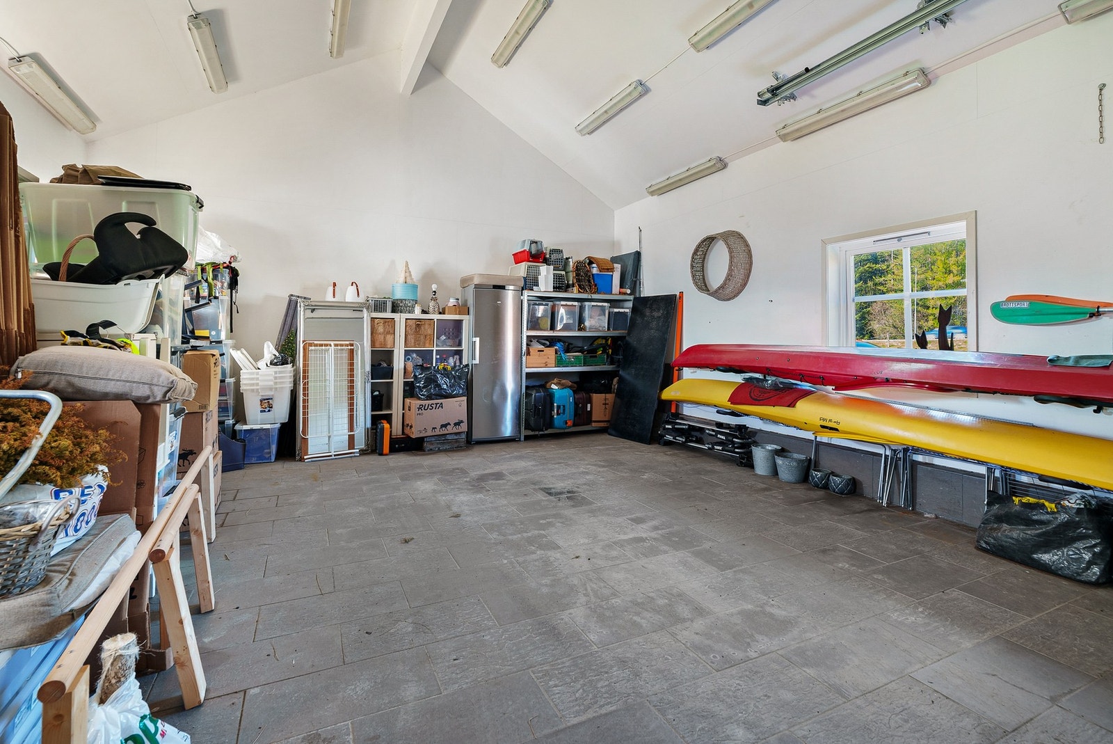 Stor garasje med elektrisk portåpner, vinduer og ytterdør. Galleribilde