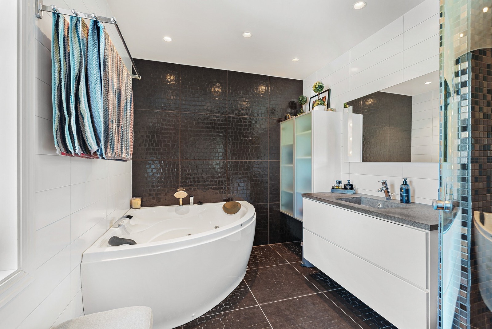 Praktisk tilrettelagt med 2 servanter i hver ende, badekar og flislagt dusjhjørne. Galleribilde