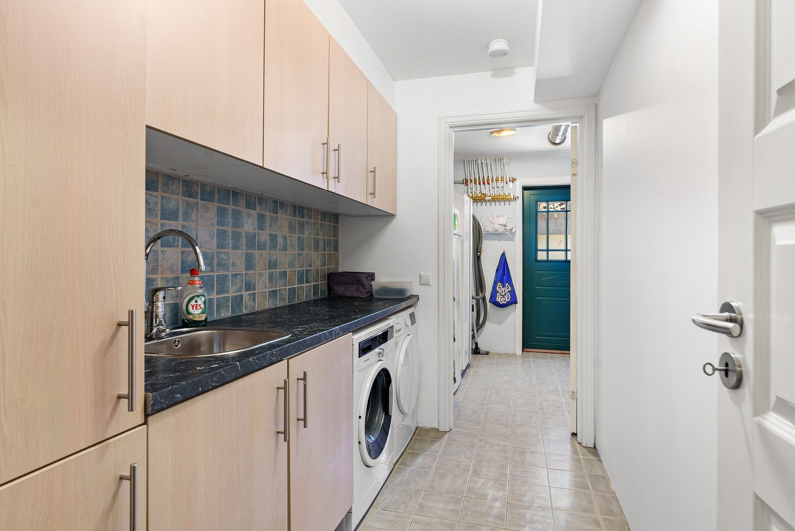 Vaskerom i kjeller med flislagt gulv, vaskemaskin, tørketrommel og god oppbevaring. Dør til østsiden av bygget, like ved inngangsdøren til utleiedelen. Galleribilde