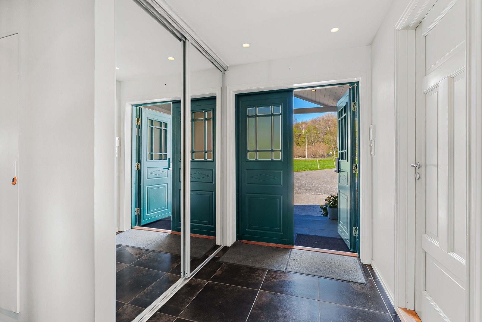 Velkommen inn til en elegant og lys entré med flislagt gulv Galleribilde