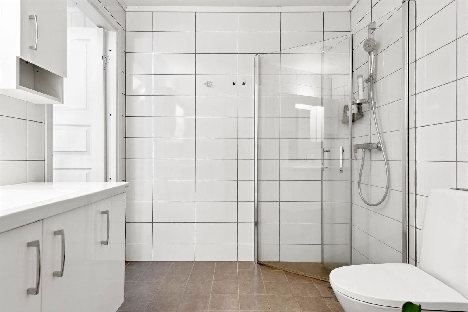 Badet har vegghengt wc og dusjhjørne med innfellbare dører Galleribilde