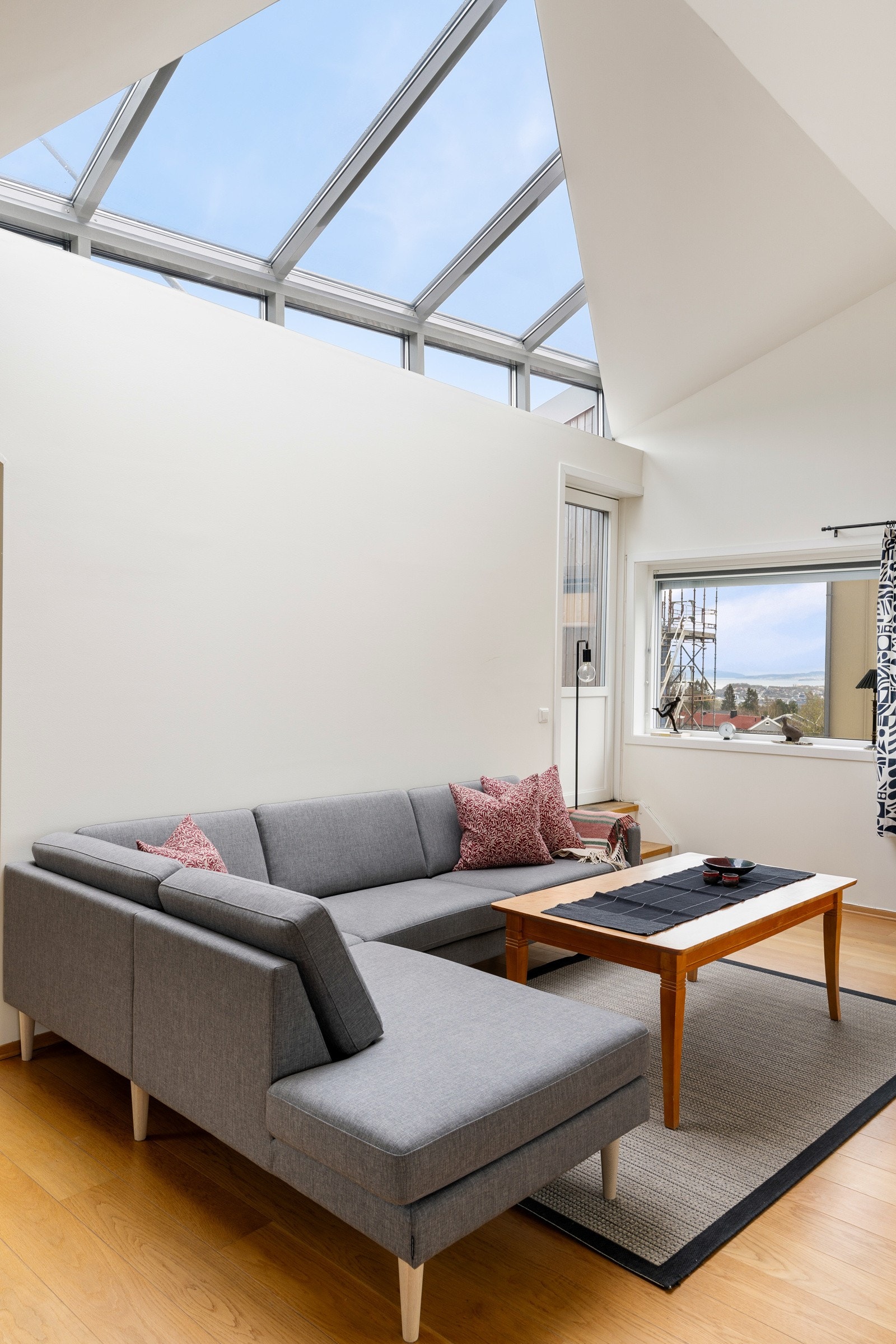 Store vindusflater og særegen takhøyde gir rikelig med naturlig lys og skaper en luftig, lys og innbydende atmosfære i boligen. Galleribilde