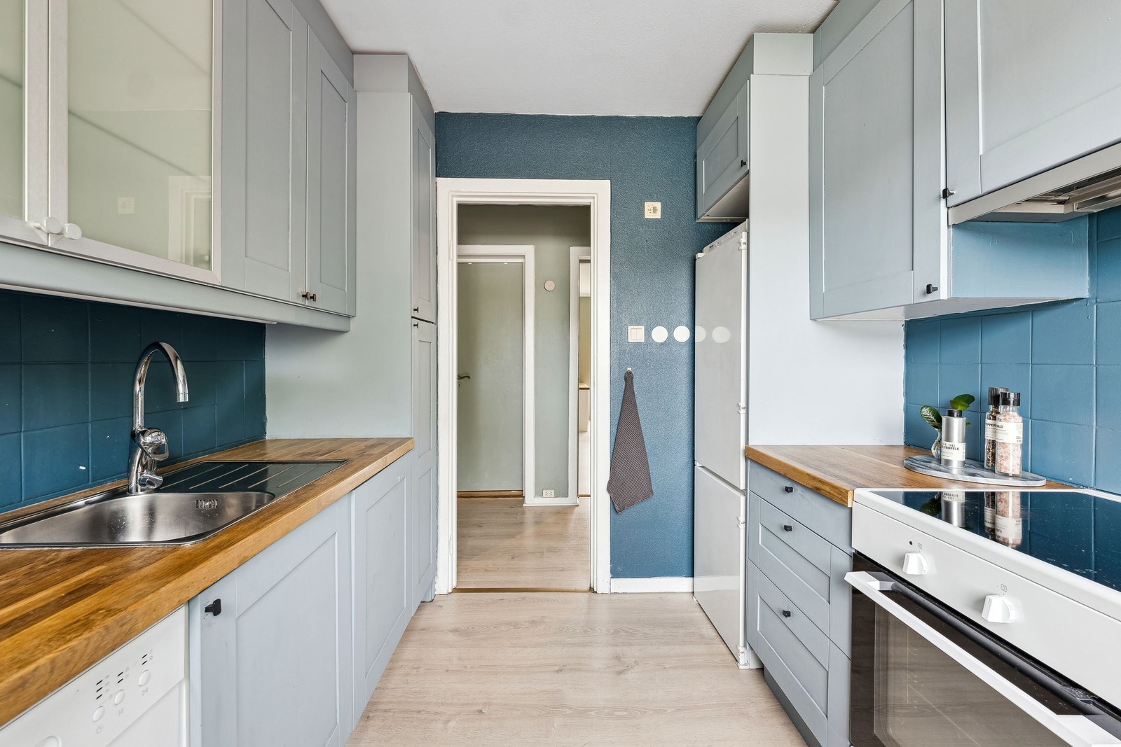 Eldre IKEA kjøkkeninnredning med malte fronter og benkeplate i heltre. Galleribilde