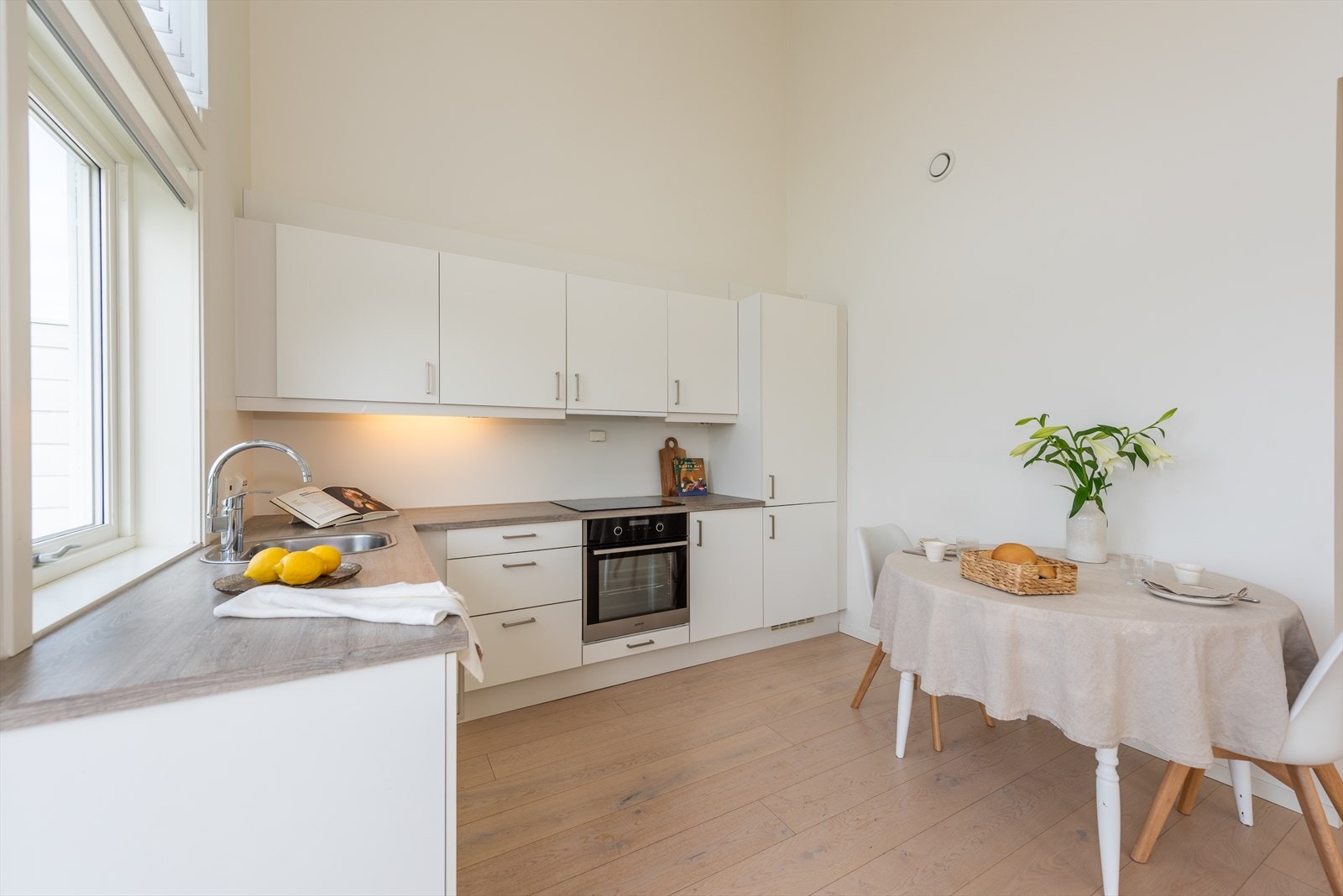 Sigdal kjøkken med hvite slette fronter fronter og laminat benkeplate. Galleribilde