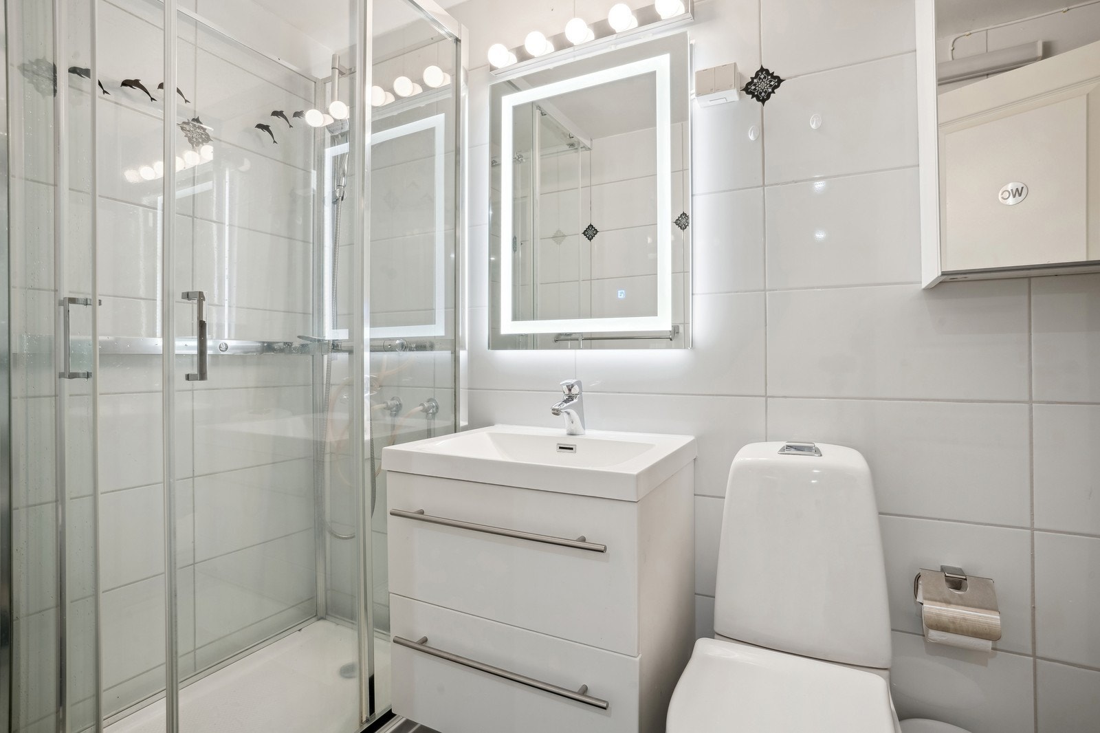 Moderne og praktisk bad med fliser og gode løsninger for oppbevaring. Galleribilde