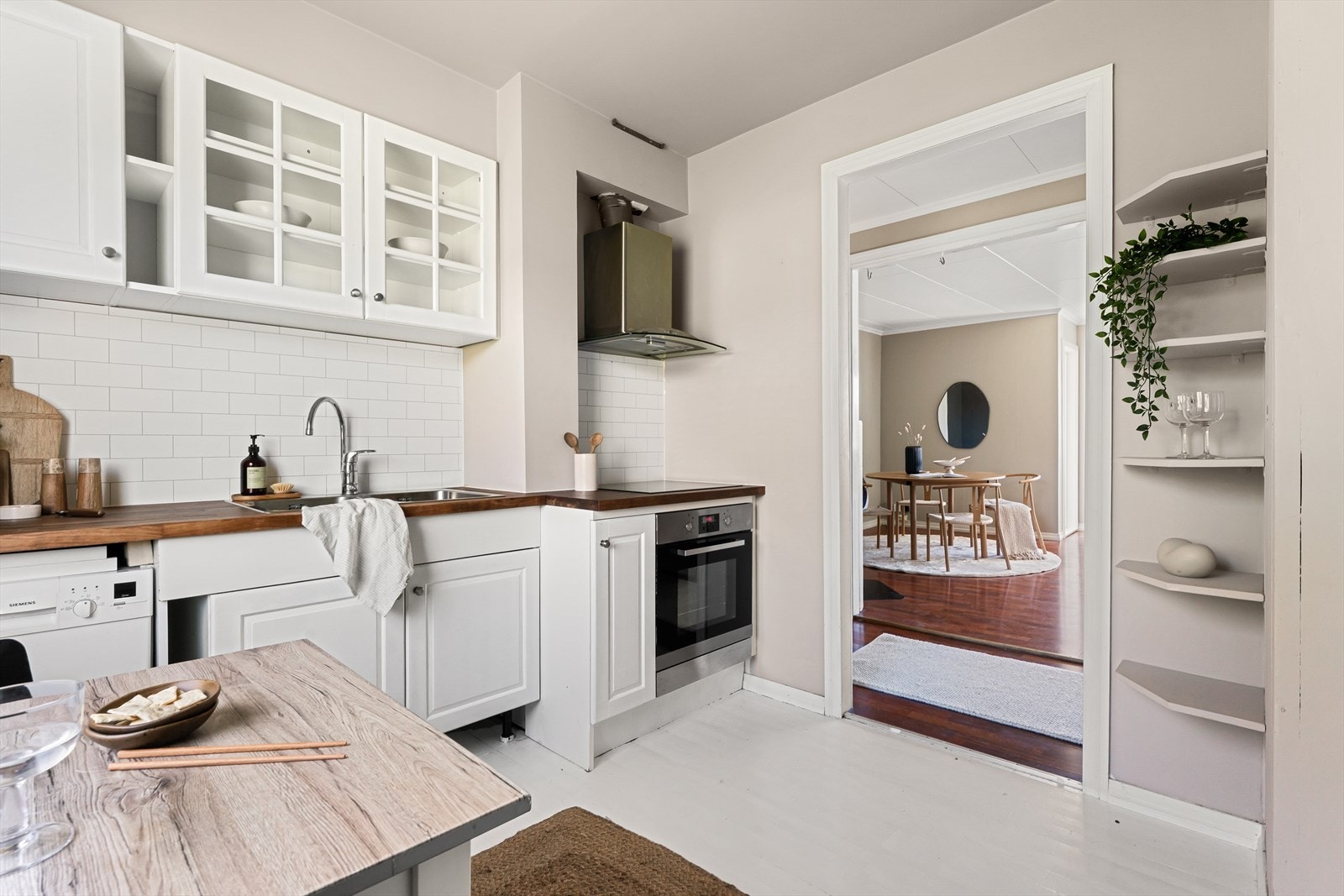 Kjøkkeninnredning med hvite fronter og oljet benkeplate med kjøkkenvask Galleribilde