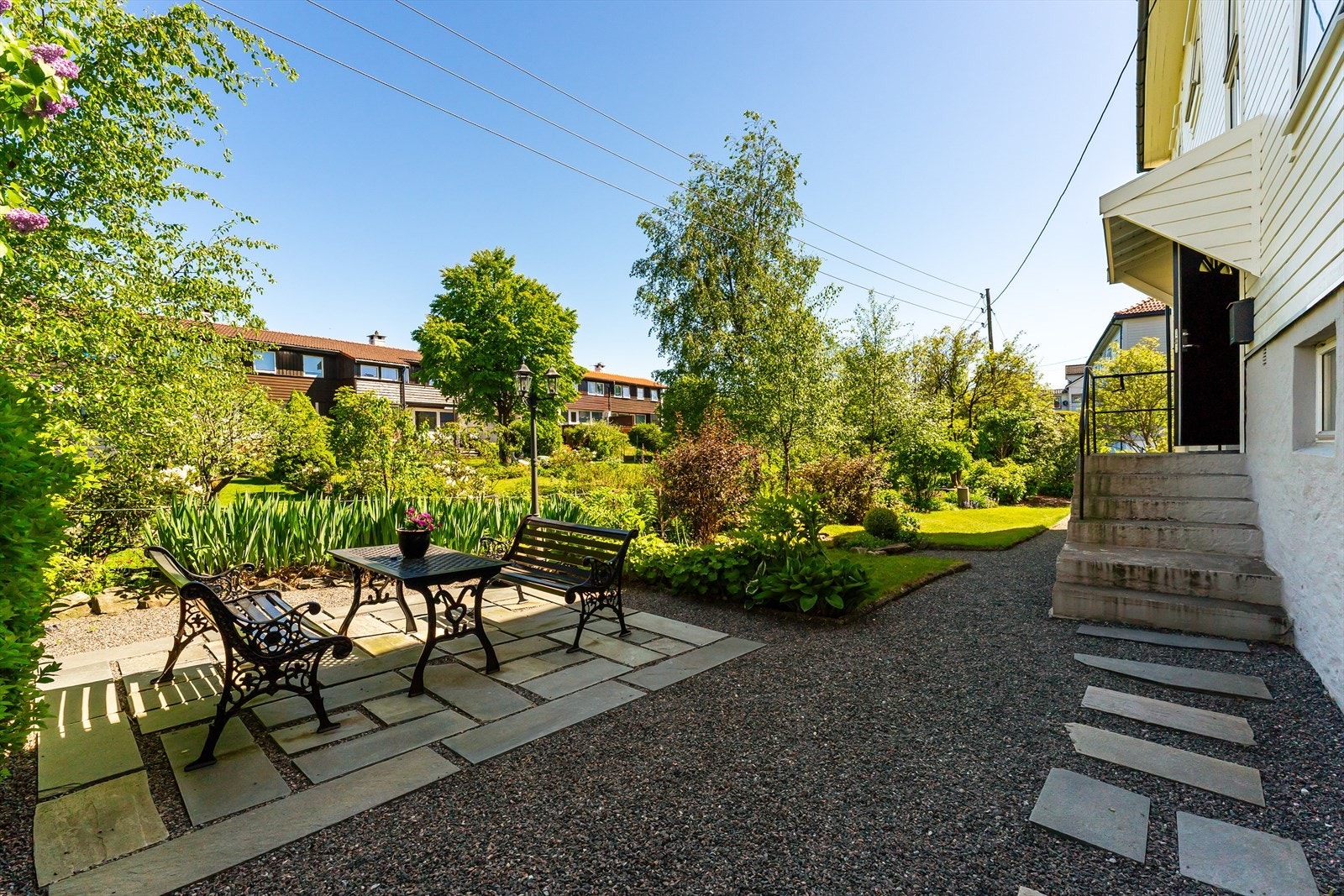 Tomten er pent opparbeidet med diverse beplantning og gangveier Galleribilde