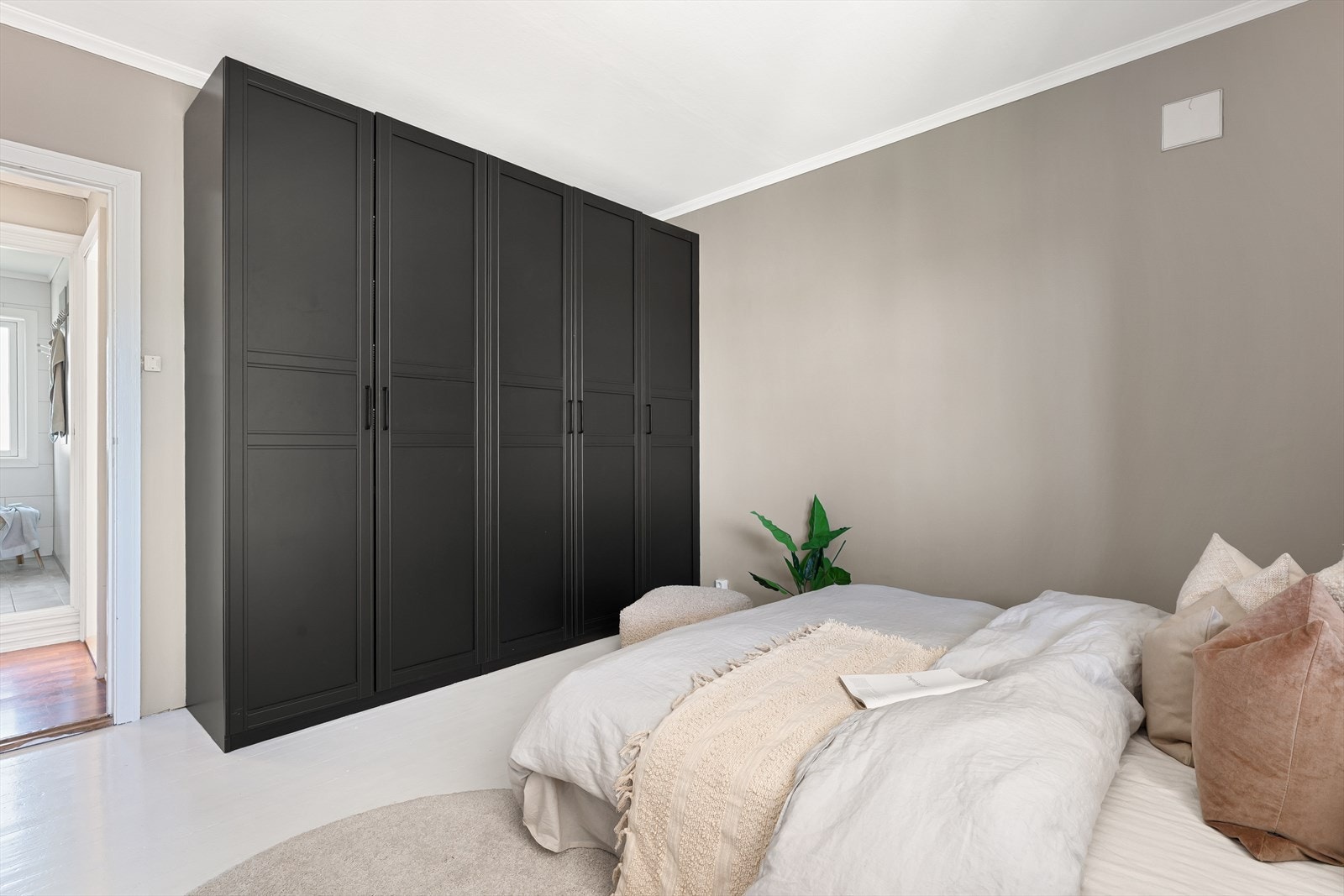 Rommet har plass til stor dobbeltseng, tilhørende nattbord og garderobeløsning Galleribilde