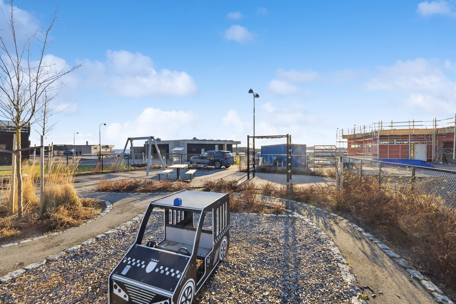 Pent opparbeidet og luftig område med felles lekeplass og parkeringsplass i boligfeltet. Galleribilde