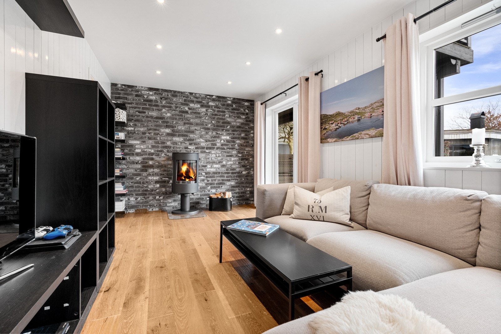 TV-stue med vedovn og utgang til uteplass Galleribilde