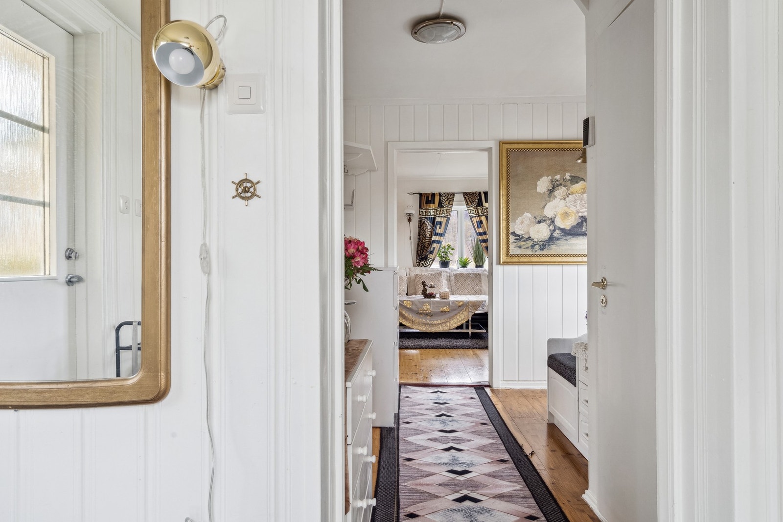 Fra entréen har man umiddelbar tilgang på en større gang, med trapp til øvrige etasjer, samt et praktisk baderom. Galleribilde