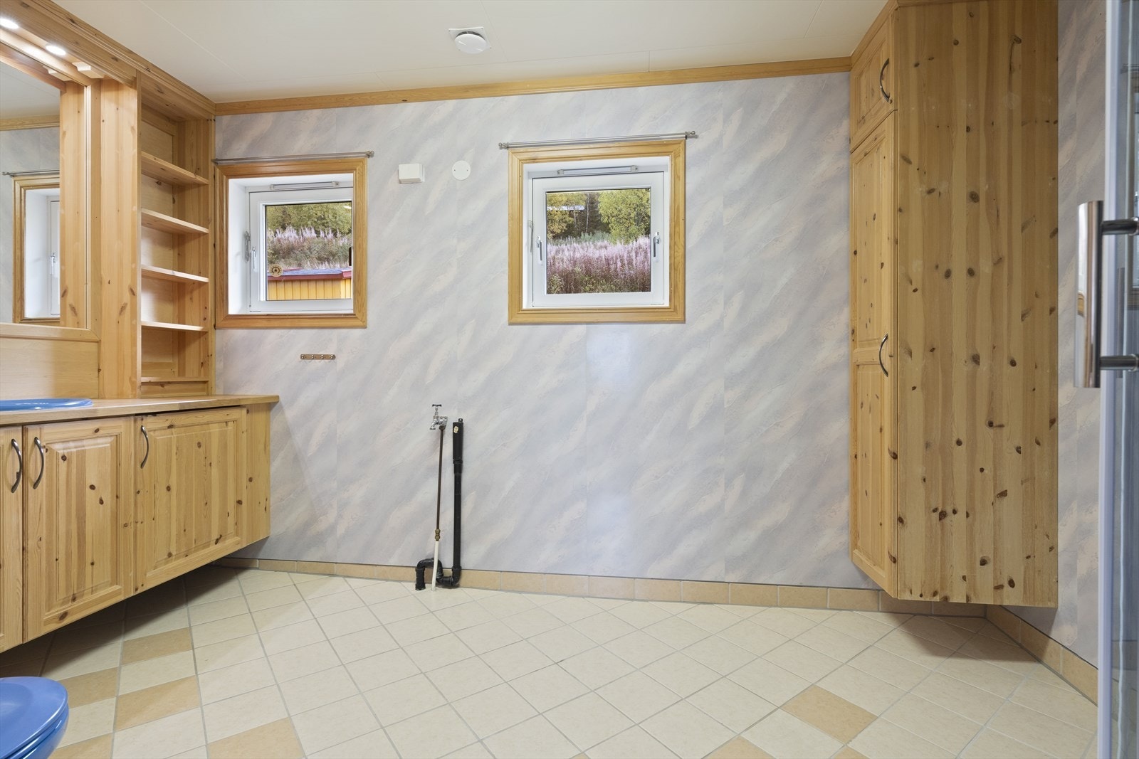 Romslig bad med baderomsinnredning i tre med nedfelt servant, toalett og dusjkabinett. Galleribilde