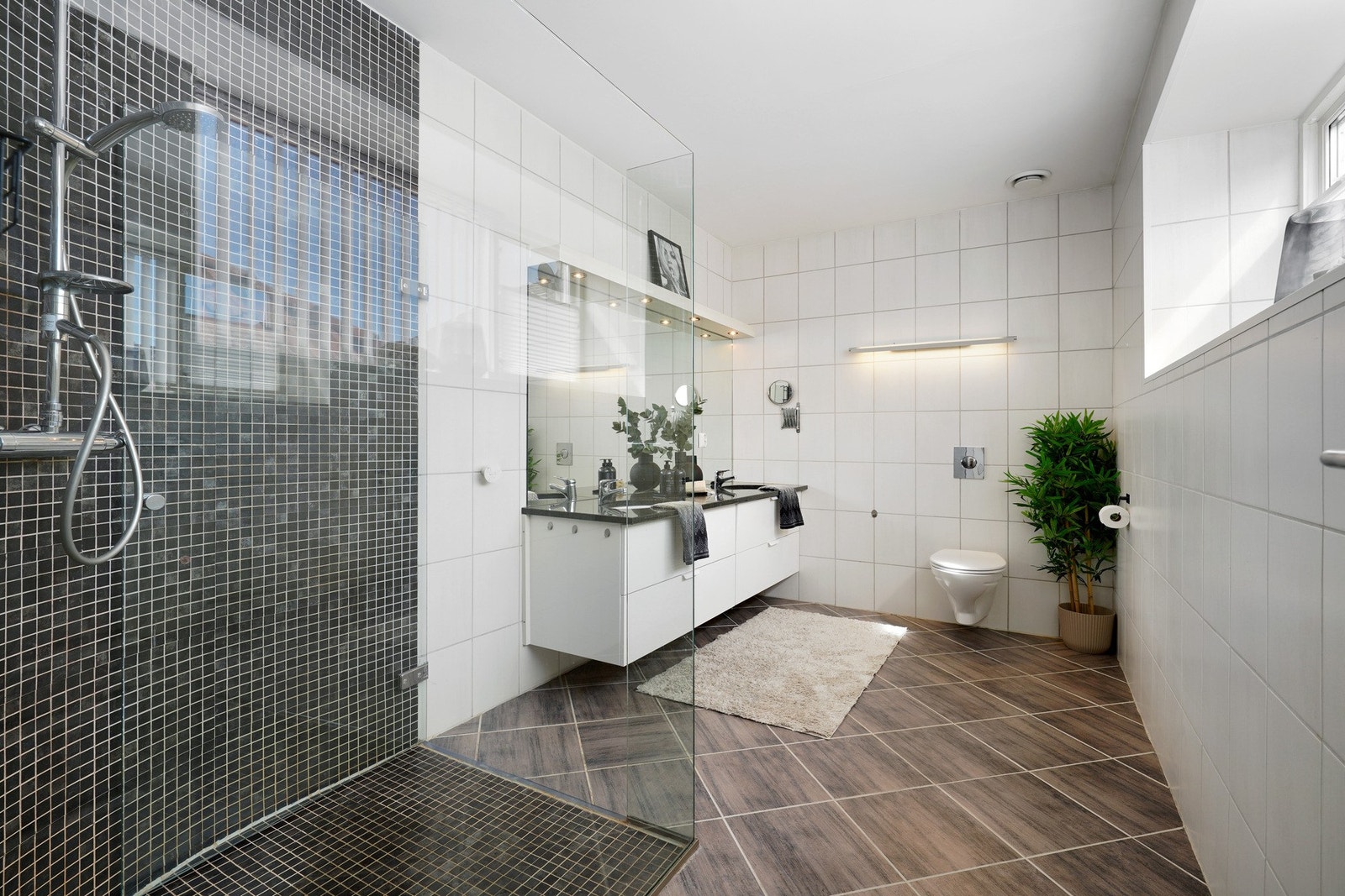 Badet er lekkert innredet med fliser på gulv og vegger Galleribilde