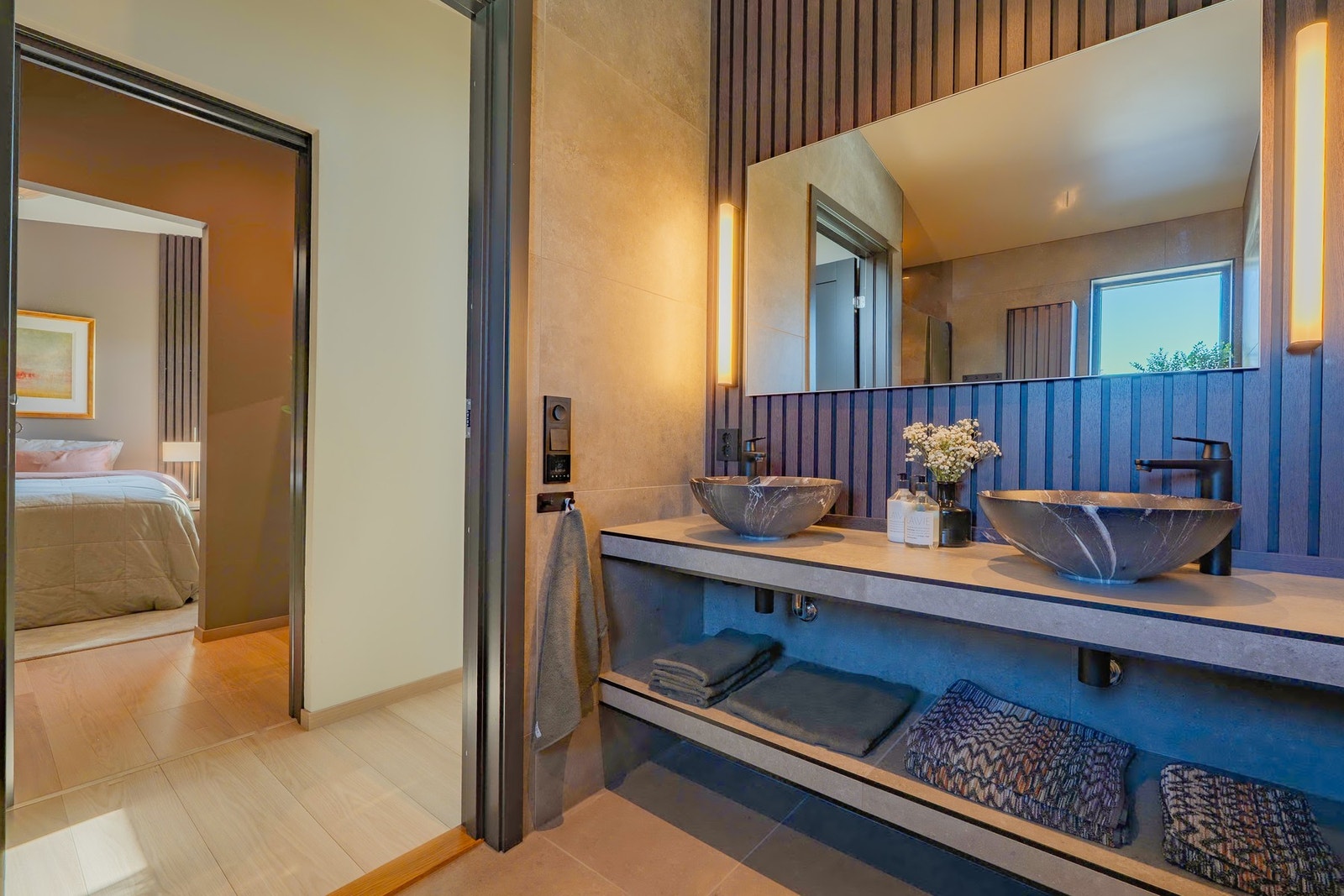 Badet har gjennomgående eksklusive materialvalg og praktiske hyller med god plass til oppbevaring. Galleribilde