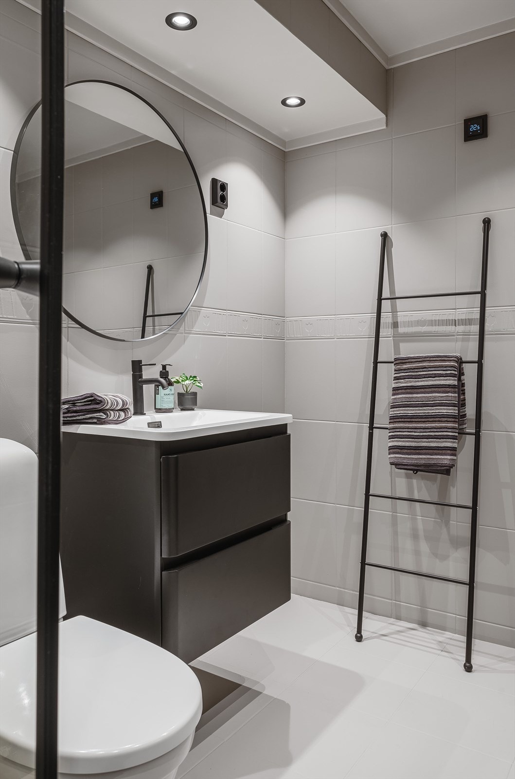 Badet er innredet med dusjkabinett, toalett, servant på innredning og speil. Galleribilde