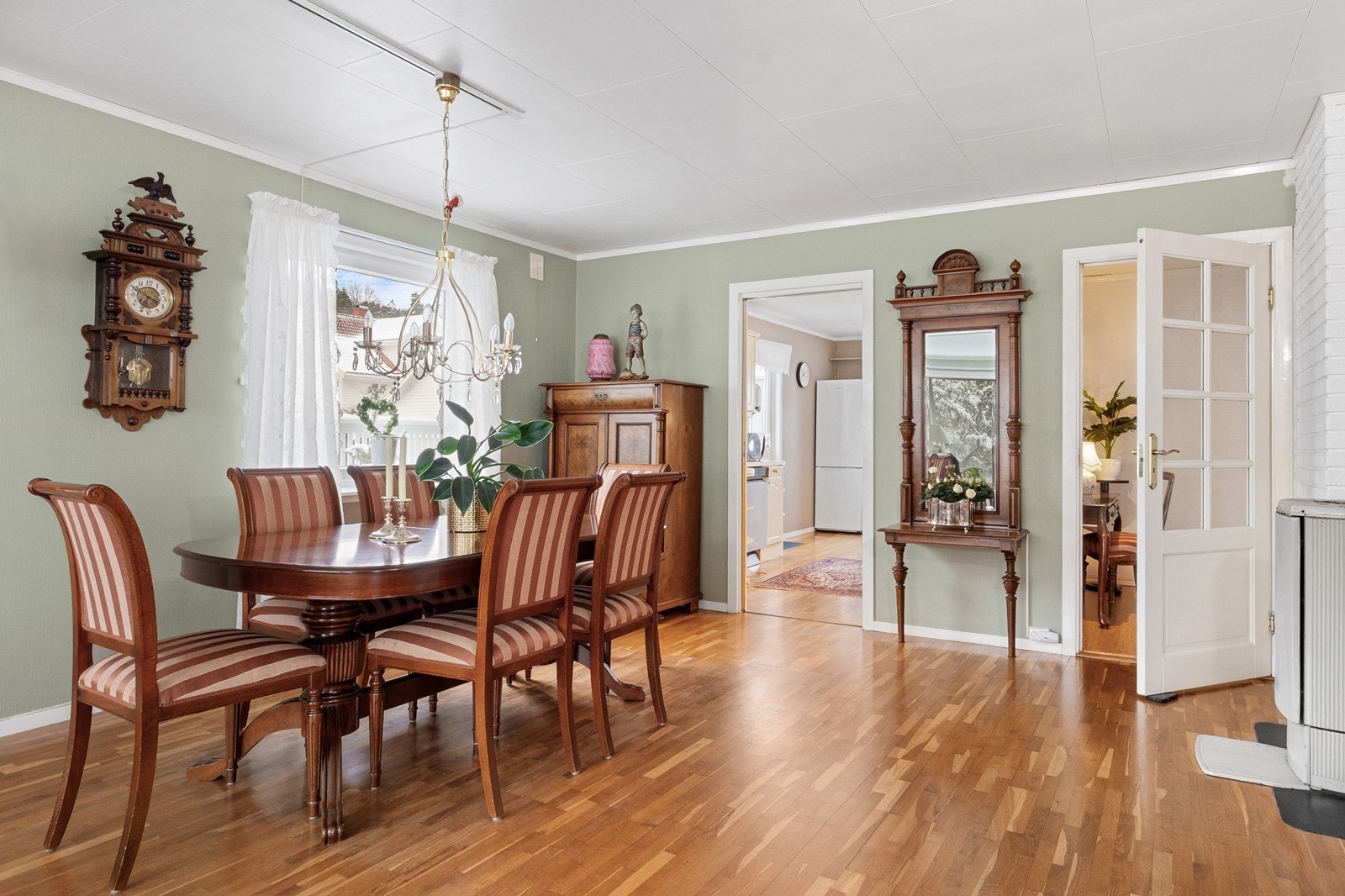 Stuen er romslig og lys med vindusflater på tre sider, en eldre kamin og varmepumpe fra 2010. Galleribilde