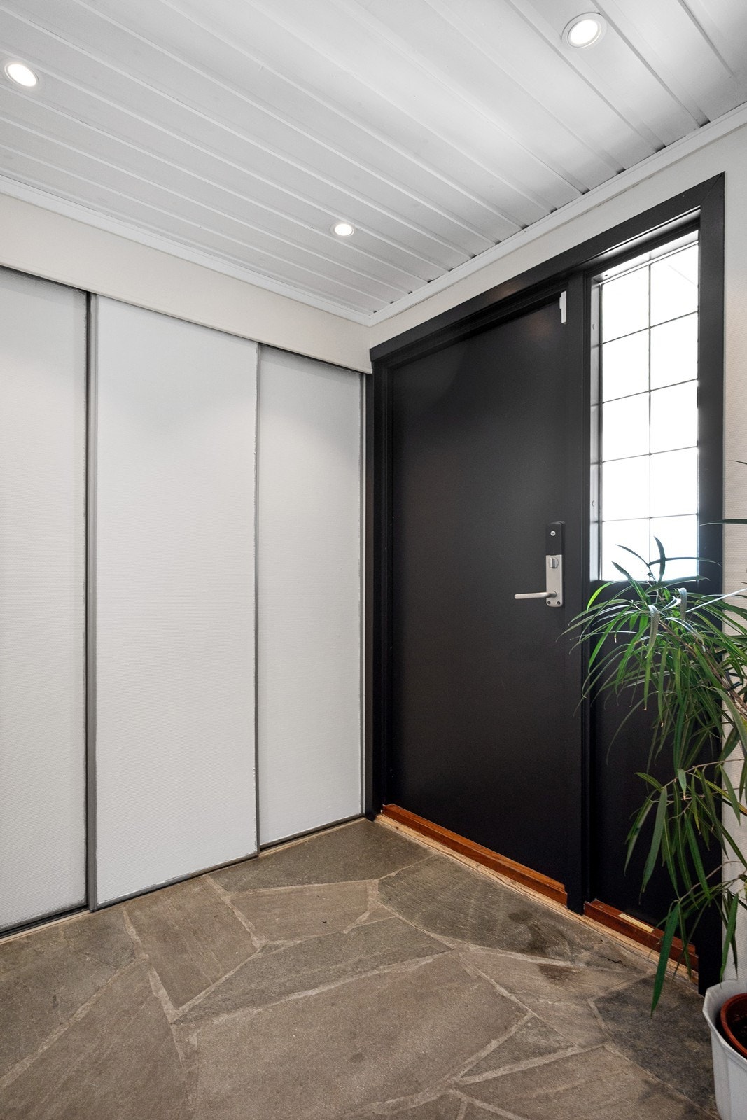 Entreen har steinheller på gulv, skyvedørsgarderobe og downlights i tak. Galleribilde