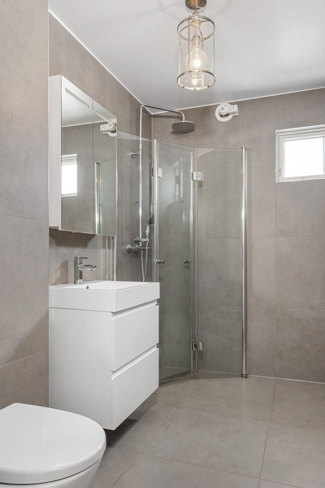 Badet fra 2017 har flislagte overflater og varmekabler, innredet med dusjhjørne, toalett, helstøpt servant og speilskap. Galleribilde