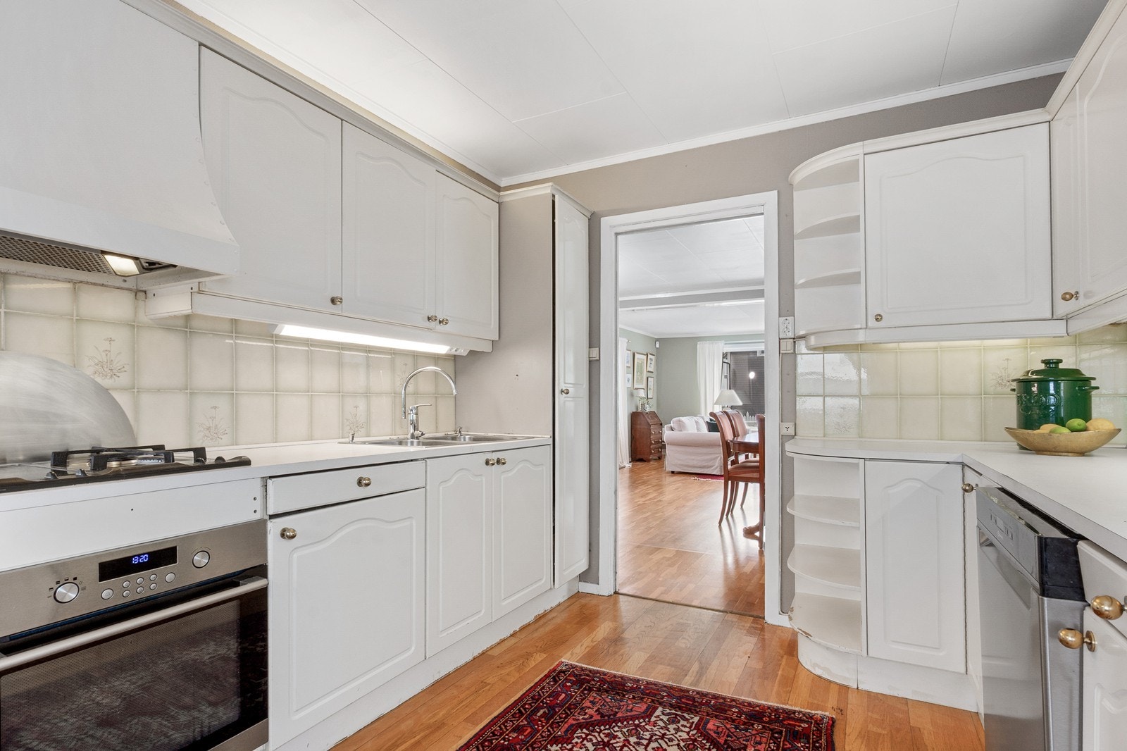 Kjøkkenet har profilerte fronter med delvis vitrineskap og benkeplate i laminat med to nedfelte oppvaskkummer. Galleribilde