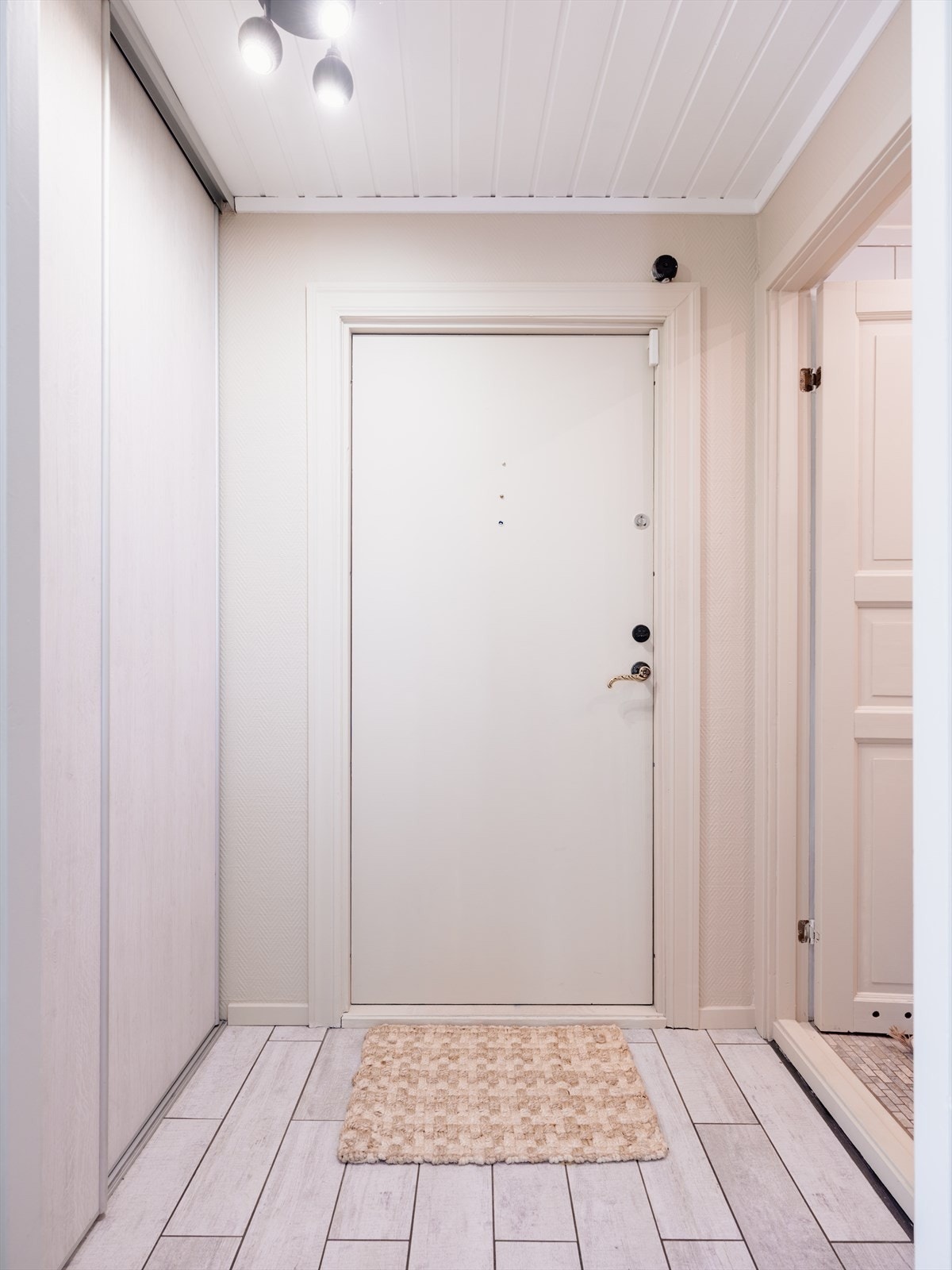 En lys og hyggelig entré ønsker deg velkommen inn. Skyvedørsgarderobe for oppbevaring av yttertøy og sko t.v. Galleribilde