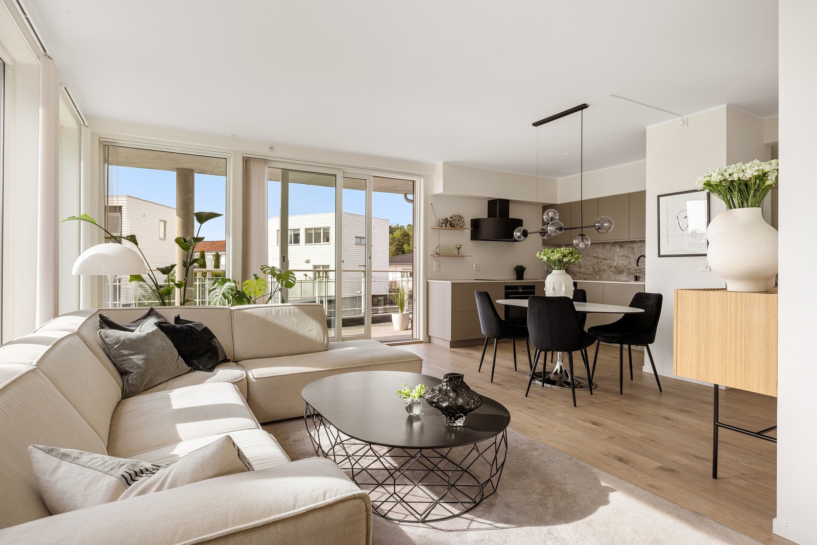 En åpen og luftig planløsning som kombinerer stue og kjøkken på en elegant måte. Galleribilde