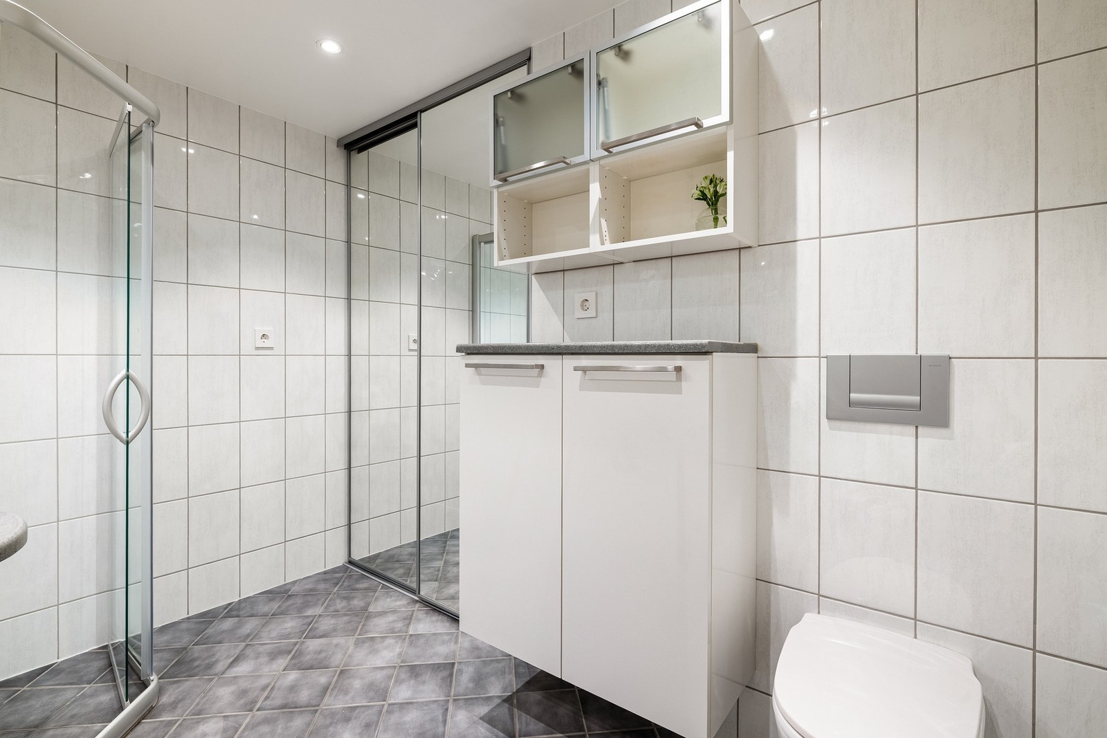 Vaskemaskinen skjules bak skyvedører for et ryddig førsteinntrykk. Galleribilde