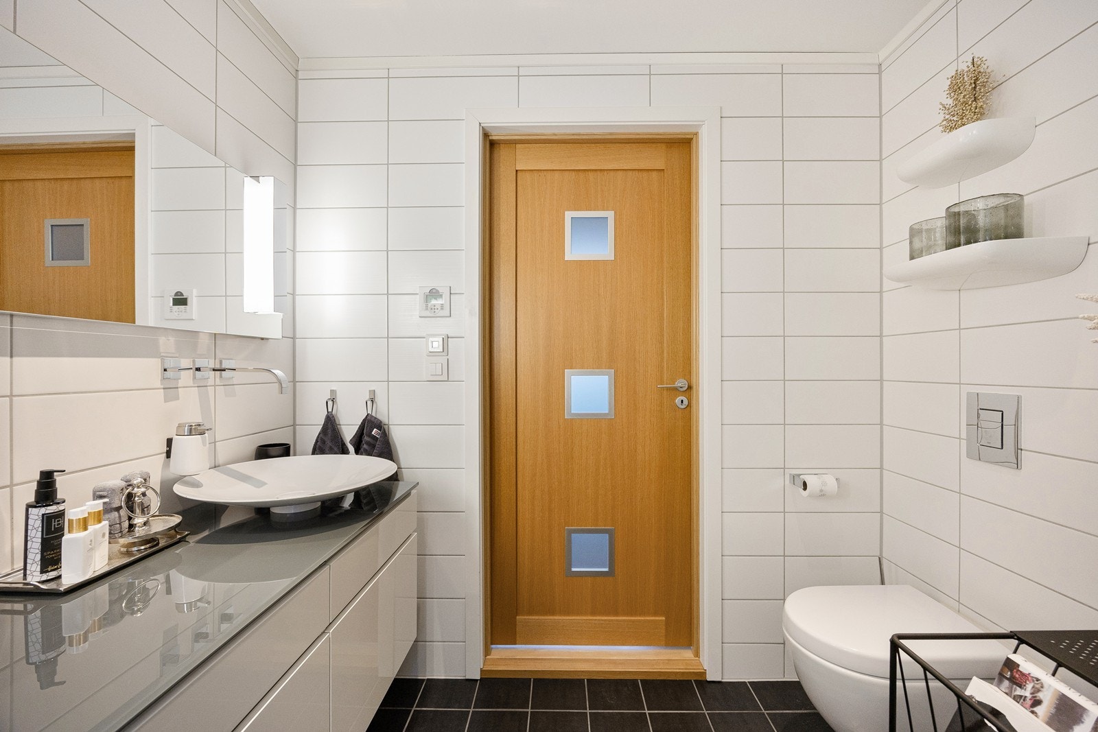 Det er skålformet servant montert på topp av benkeplaten og pent veggmontert armatur. Galleribilde