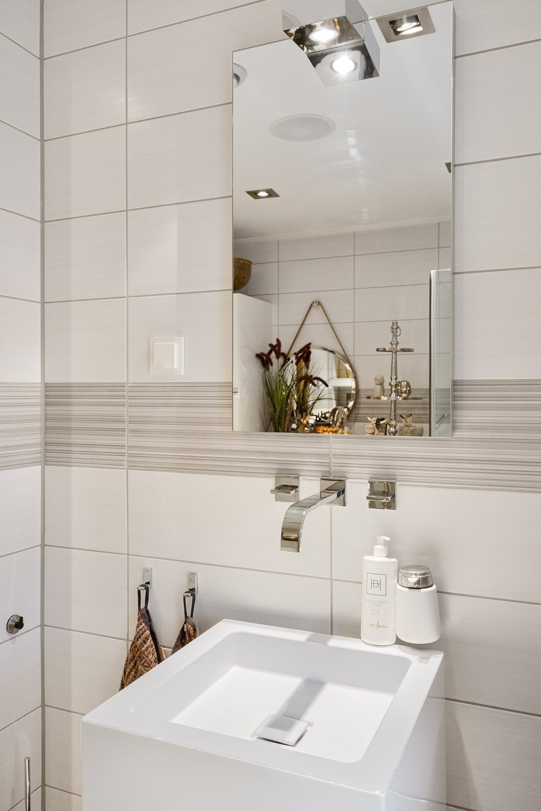 Designet er gjennomført med hvit helstøpt servant i høyglans og veggmontert armatur som setter prikken over i'en for designet. Galleribilde