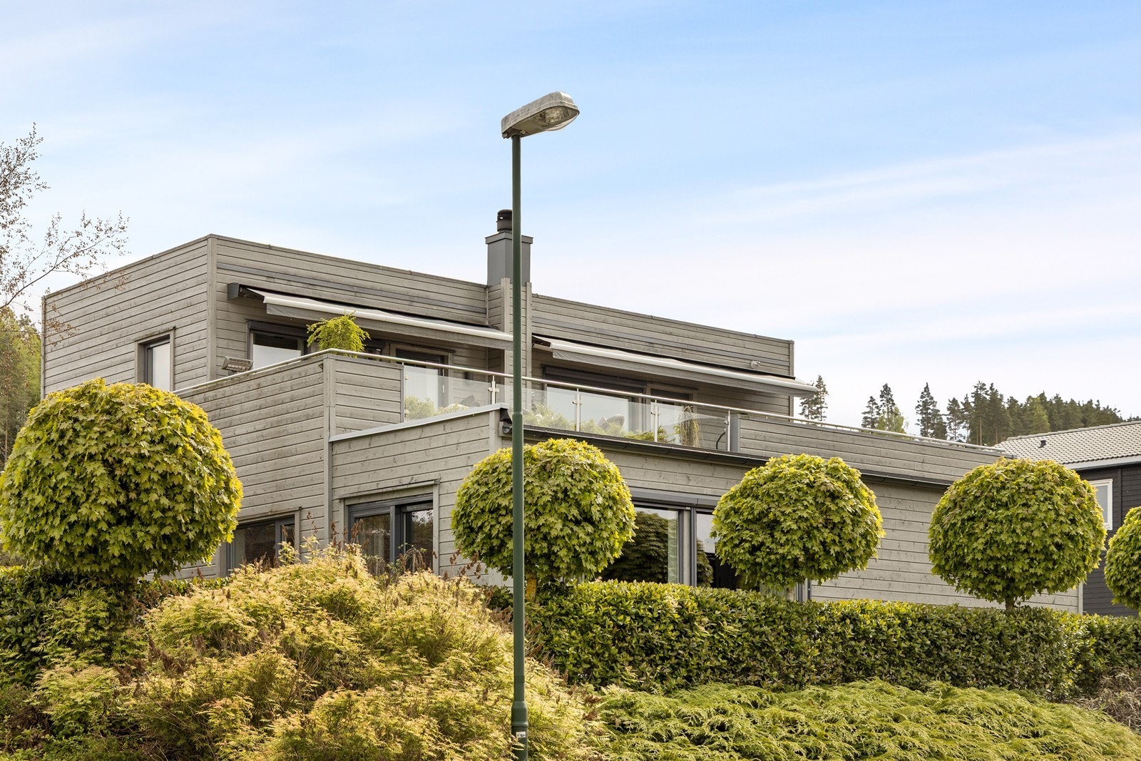 Hekk og trær rundt huset er pent frisert. Galleribilde