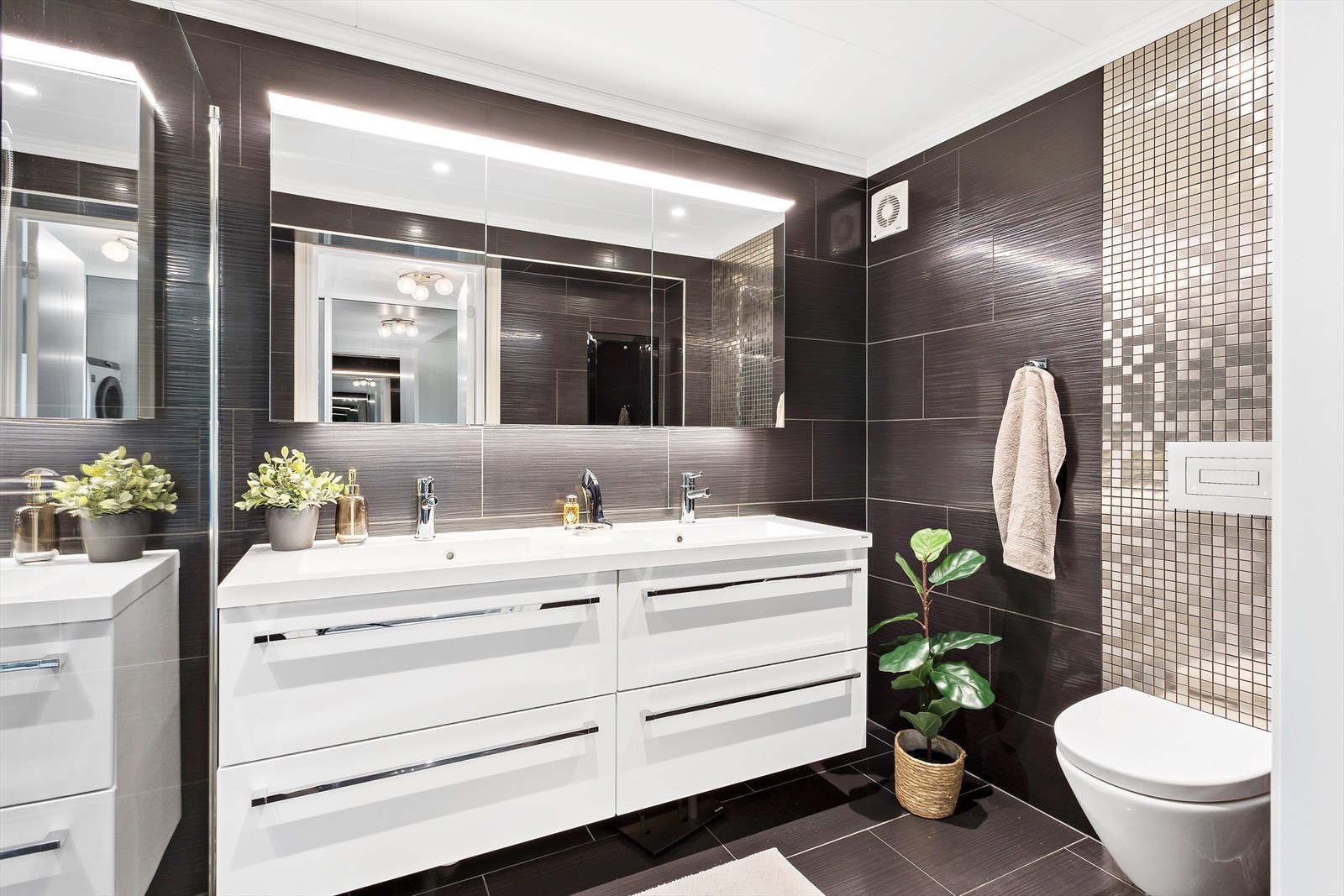 Lekkert bad pusset opp i 2016 som har innredning med dobbelservant, speil med integrert belysning, vegghengt toalett og dusjsone med glassvegg. Galleribilde