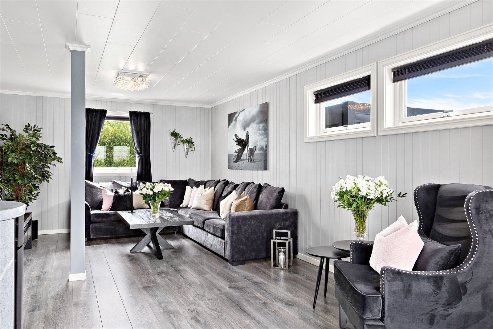 Stuen er lys og luftig med laminat på gulv og malte panelplater på vegger. Galleribilde