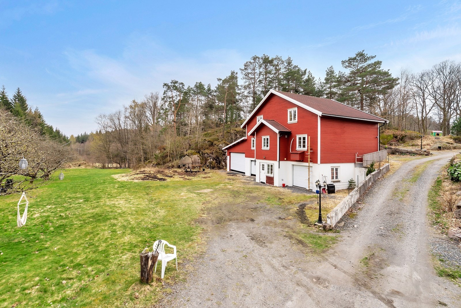 Uteområdet med stor gressplen og gruset vei. Galleribilde