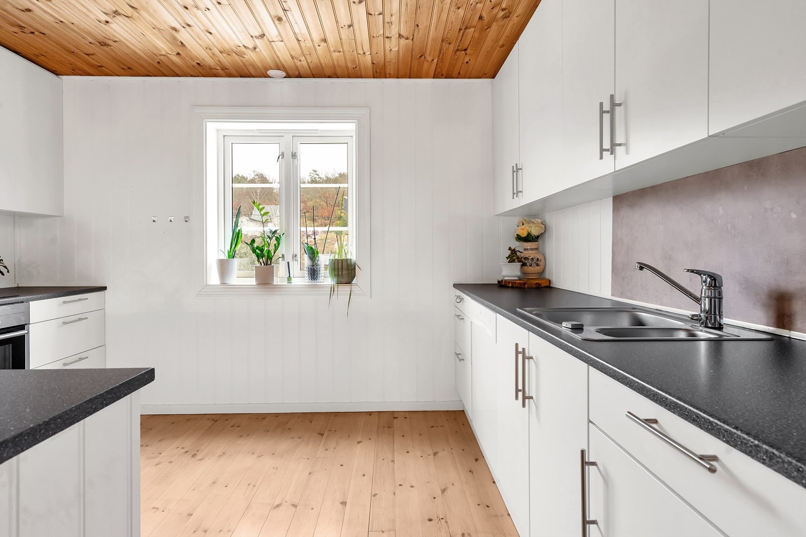 Hvite overflater gir kjøkkenet en lys og luftig atmosfære. Galleribilde