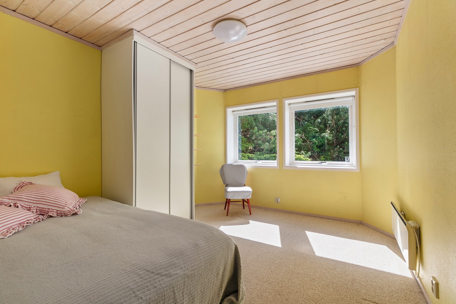 Soverom 2 har to vinduer og innredning med dobbeltseng og en liten skyvedørsgarderobe Galleribilde