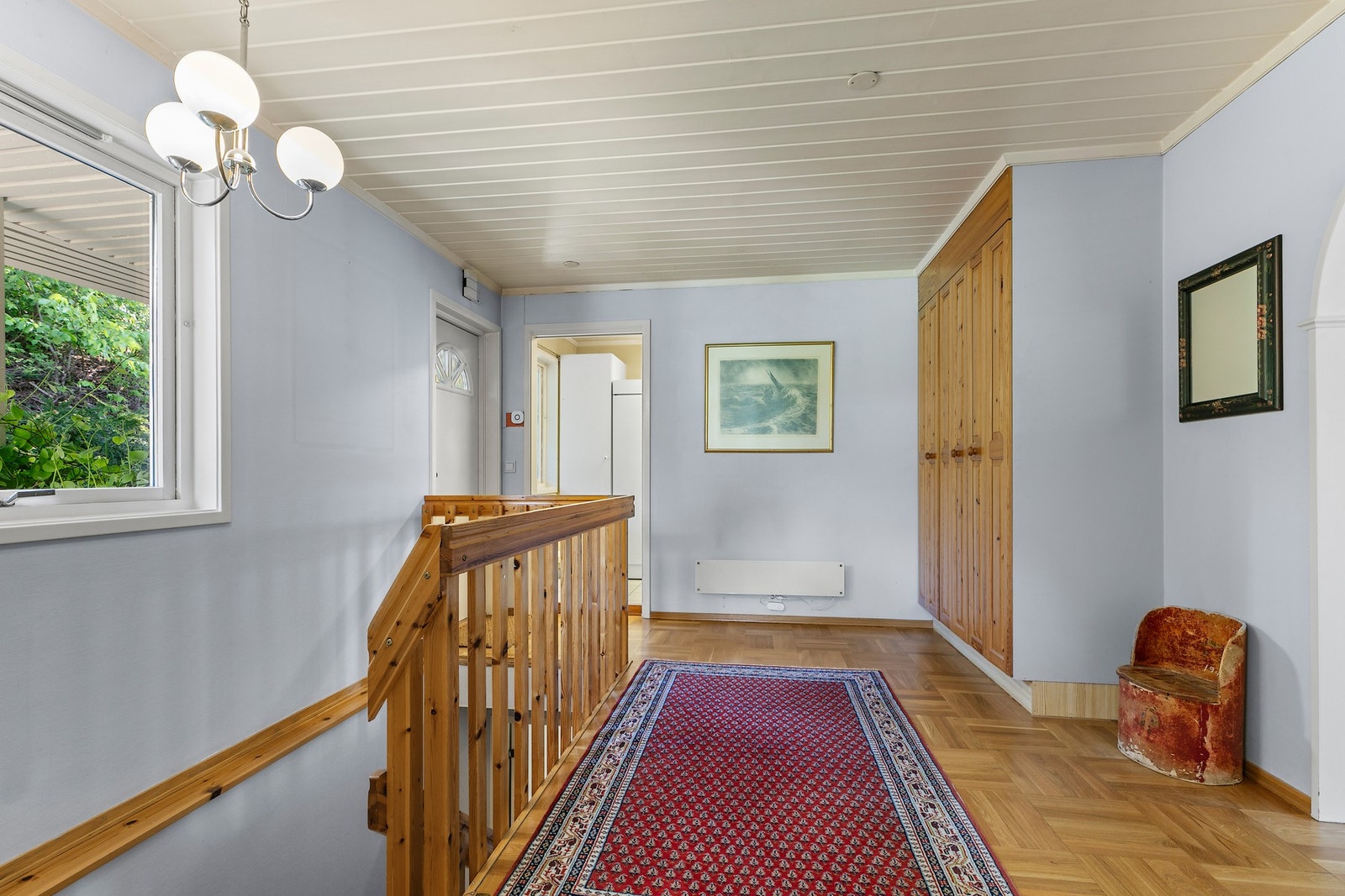 Entré/hall med skaprekke i 1. etasje, har trappeløp til etasjen under, og skyvedørsadkomst til vaskerom/grovkjøkken Galleribilde