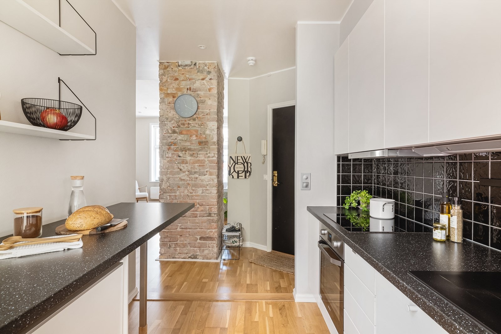 - Den røffe murveggen og stilrene kjøkkeninnredningen skaper en perfekt balanse mellom det industrielle og det elegante - Galleribilde