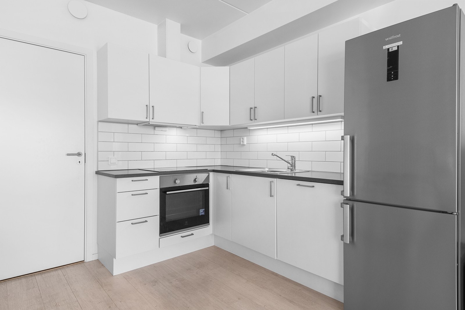 Kjøkkenet har lyse fronter, ovn med induksjonstopp og oppvaskmaskin Galleribilde