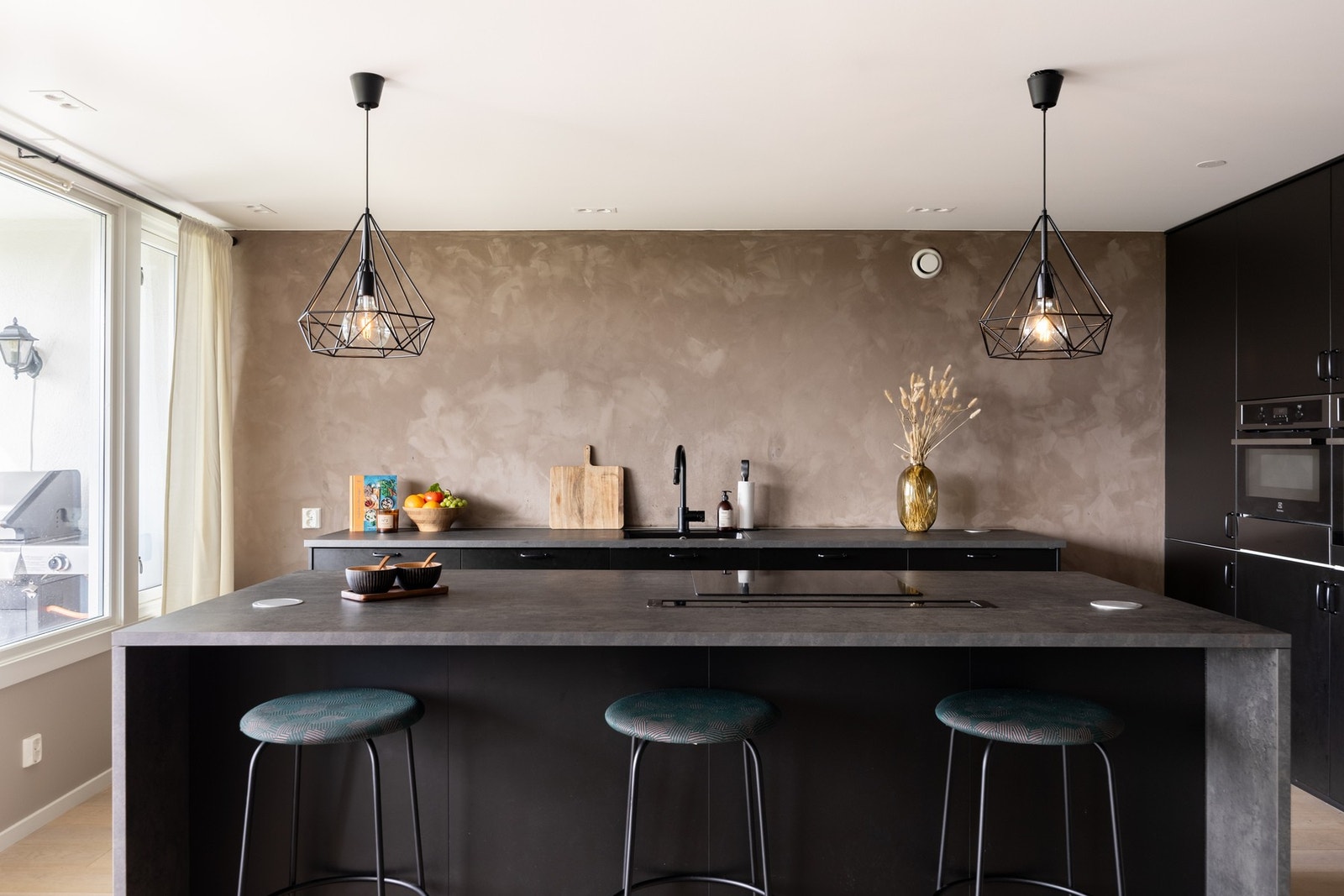 Moderne kjøkkeninnredning med åpen løsning vendt mot stue. Stor kjøkkenøy som skaper en avskilt sone. Galleribilde