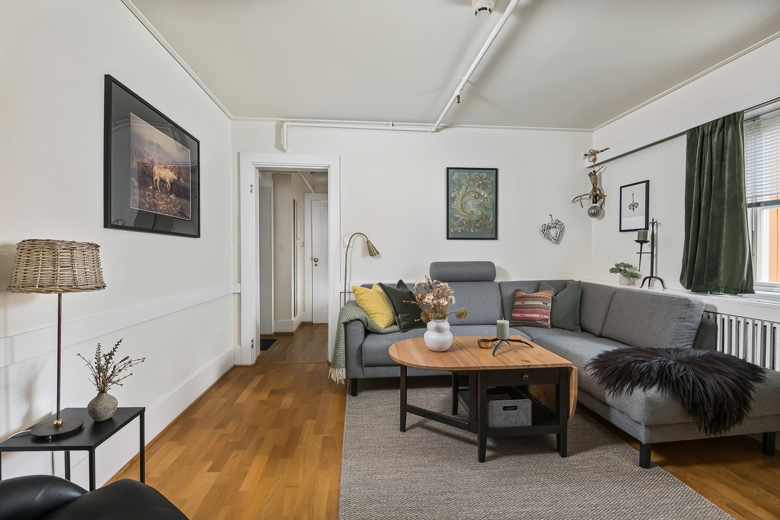 Lys og pen stue med parkettgulv og plass til stor sofa. Galleribilde