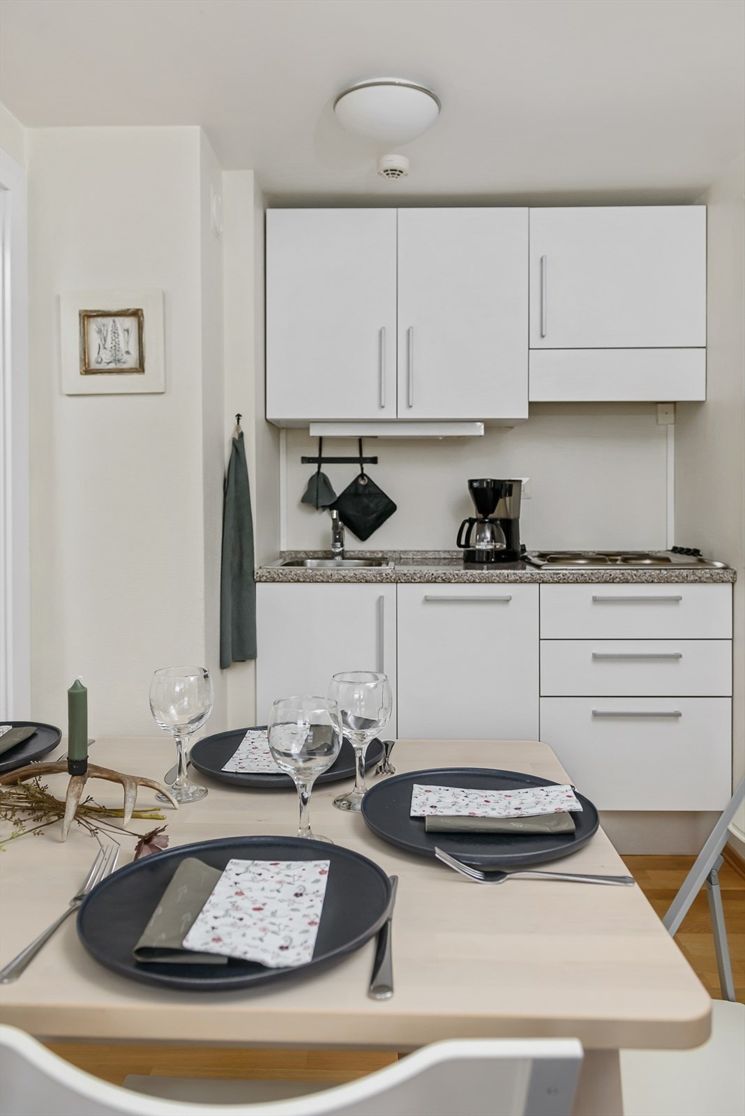 Kjøkkeninnredning med hvite slette fronter. Galleribilde